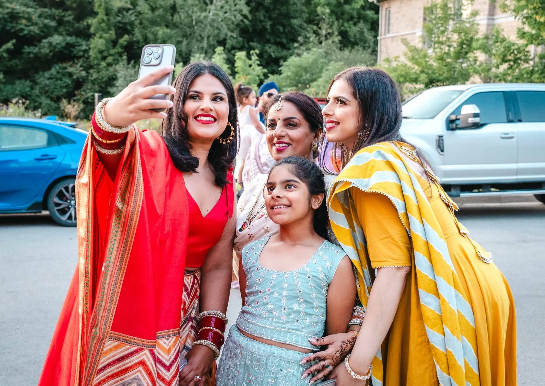 Women posing and taking photographs together at Aaron’s Haldi celebration.
