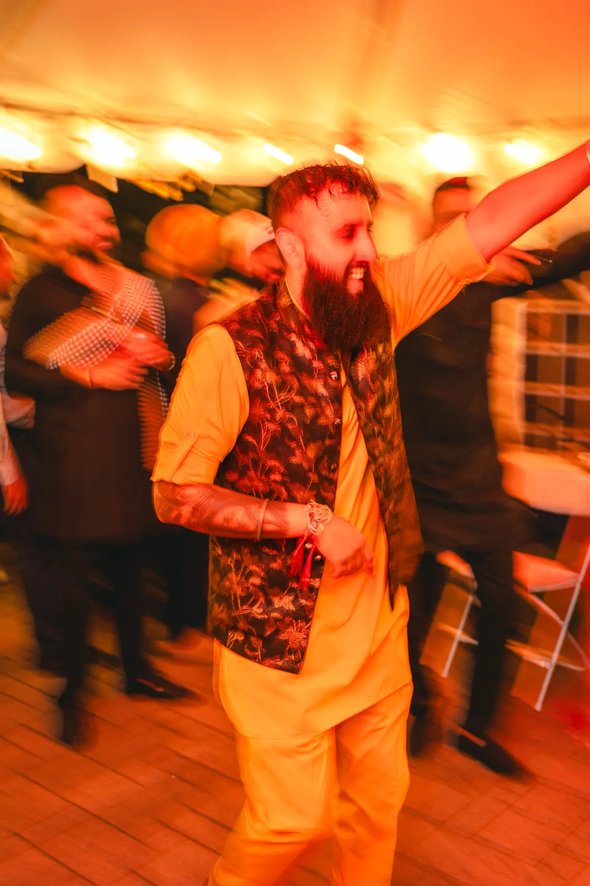 Guests dancing under evening lights at Aaron’s Haldi celebration.