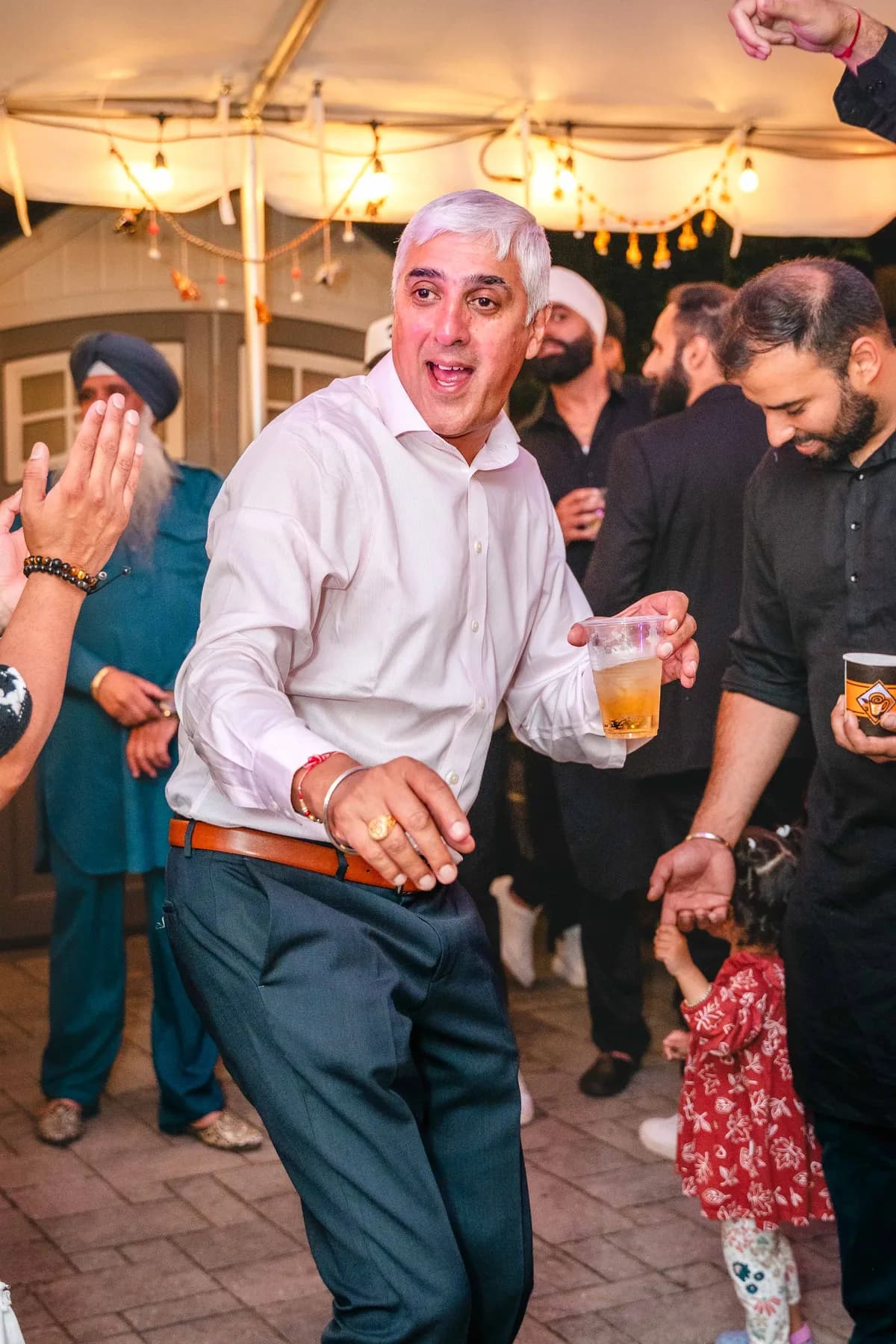 Guests dancing under evening lights at Aaron’s Haldi celebration.