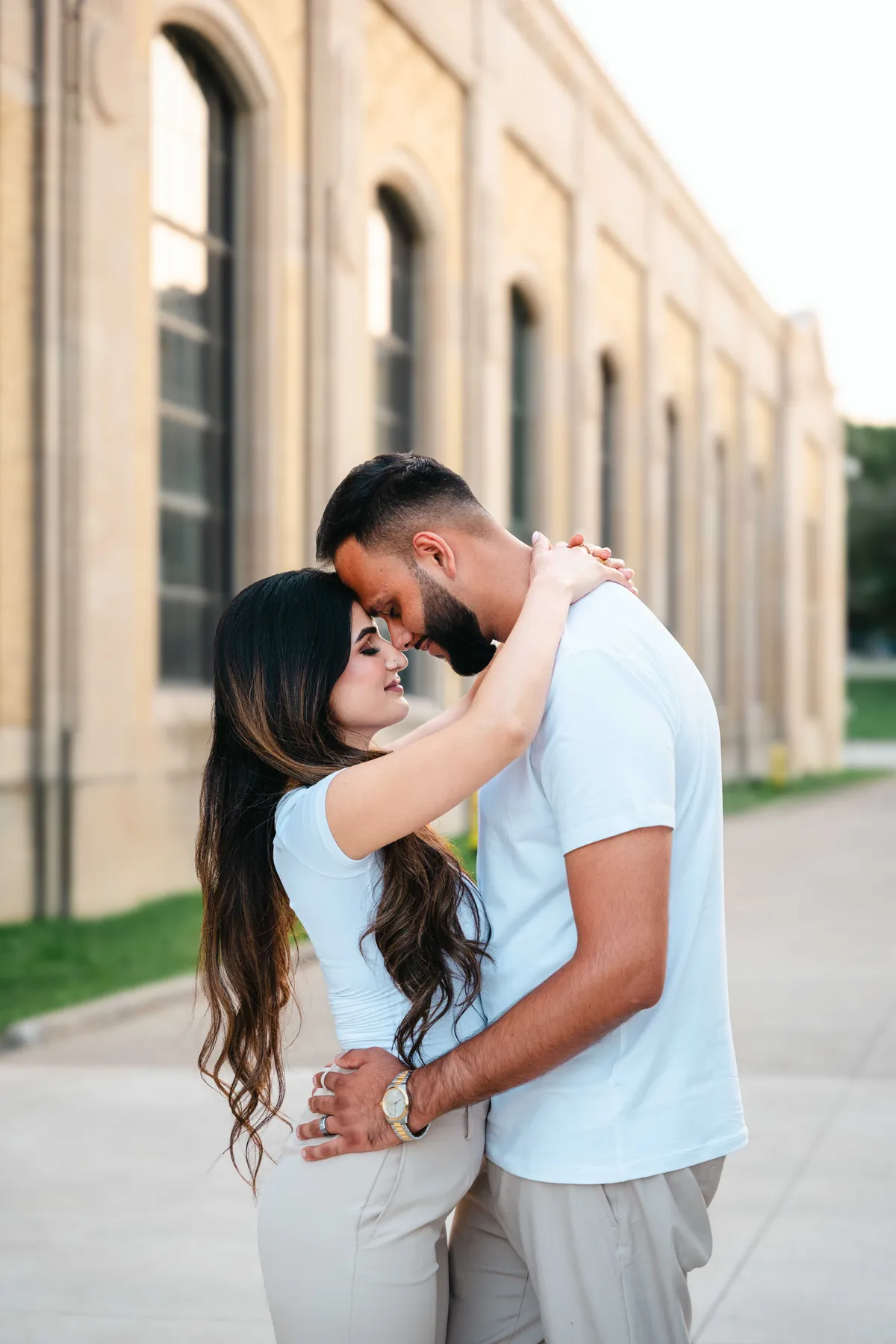 The couple embracing outside a city building at A and F’s couples session.