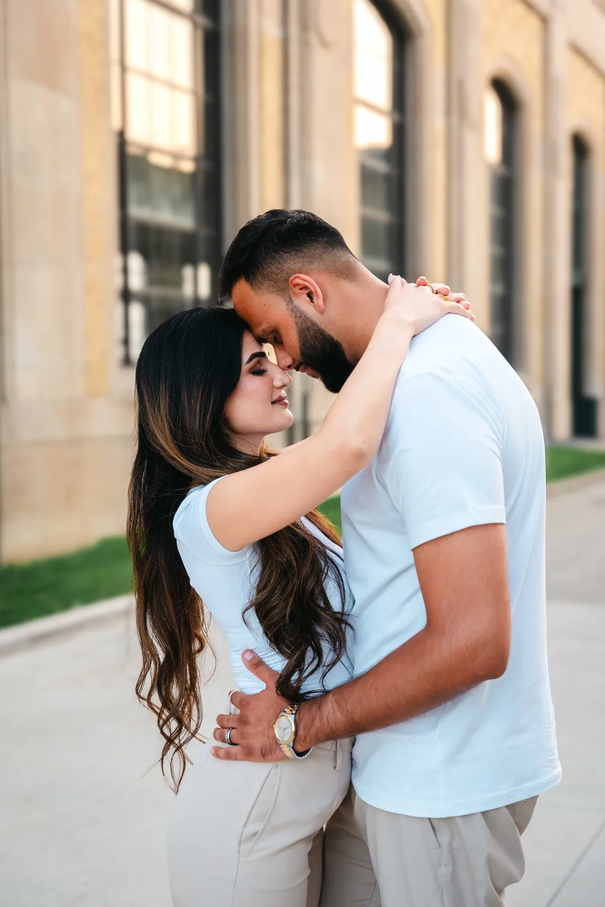 The couple embracing outside a city building at A and F’s couples session.