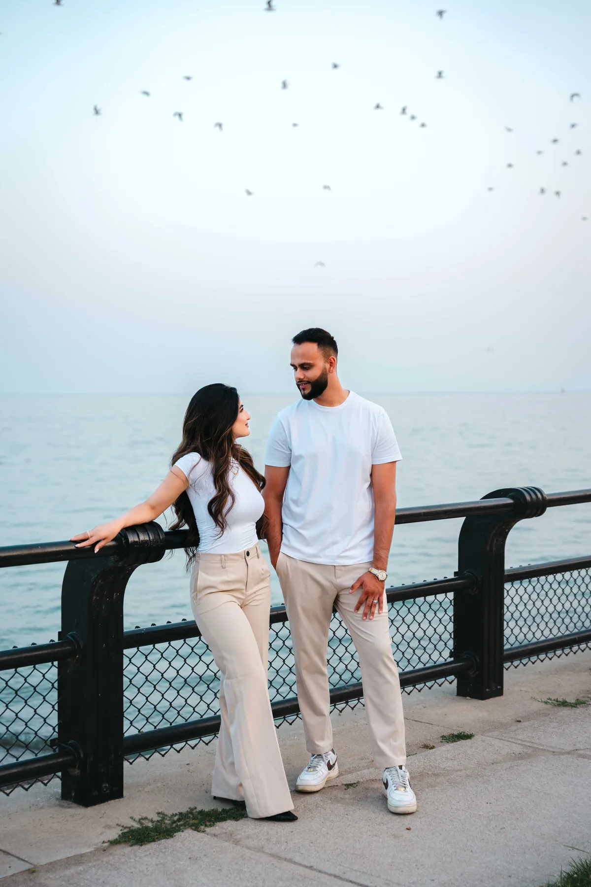 The couple beside a waterfront railing at A and F’s couples session.