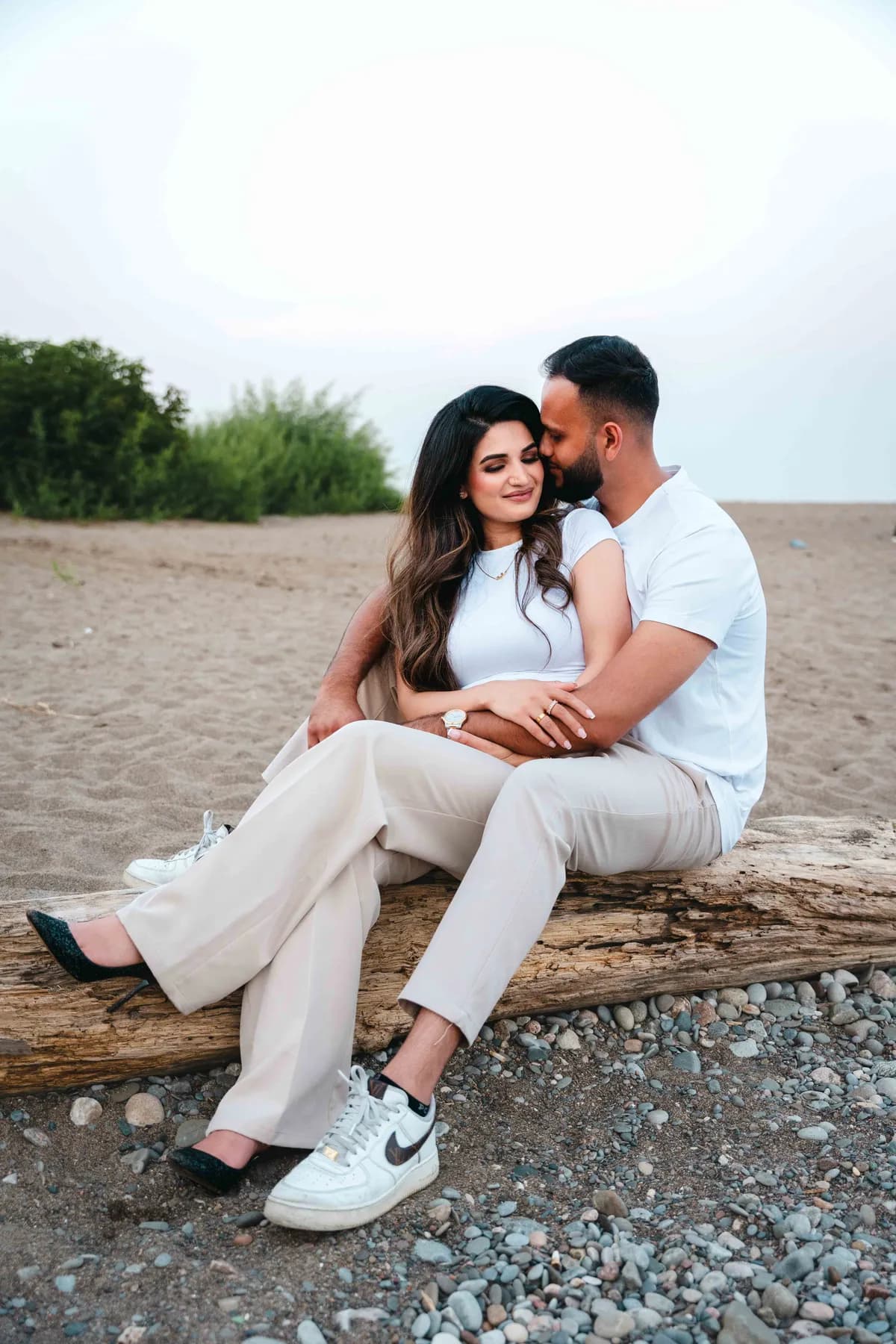 The couple seated together on the beach at A and F’s couples session.