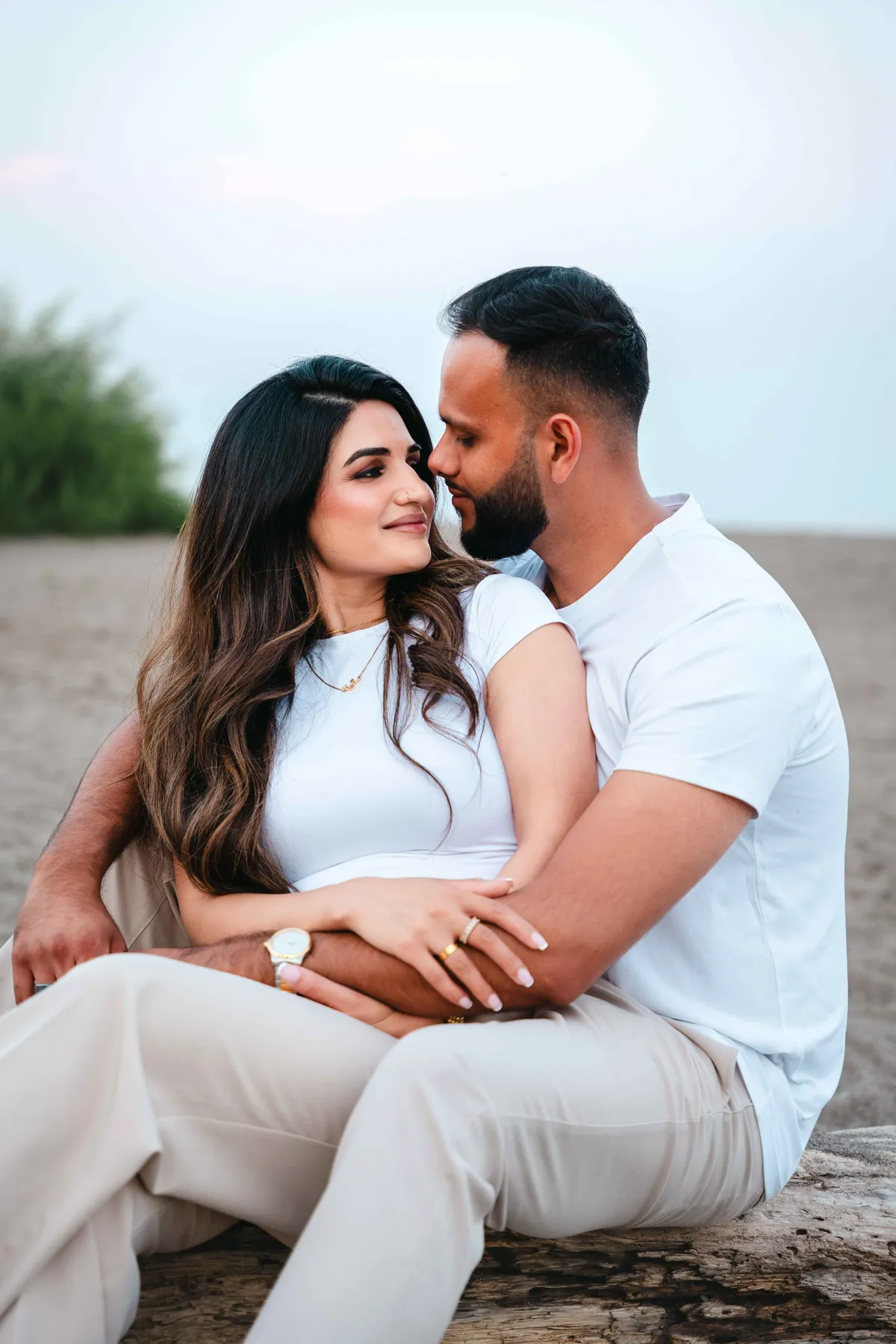 The couple seated together on the beach at A and F’s couples session.