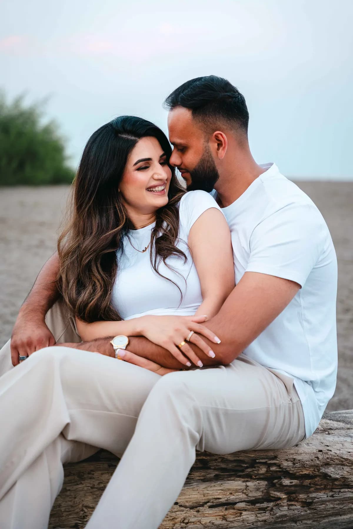 The couple seated together on the beach at A and F’s couples session.