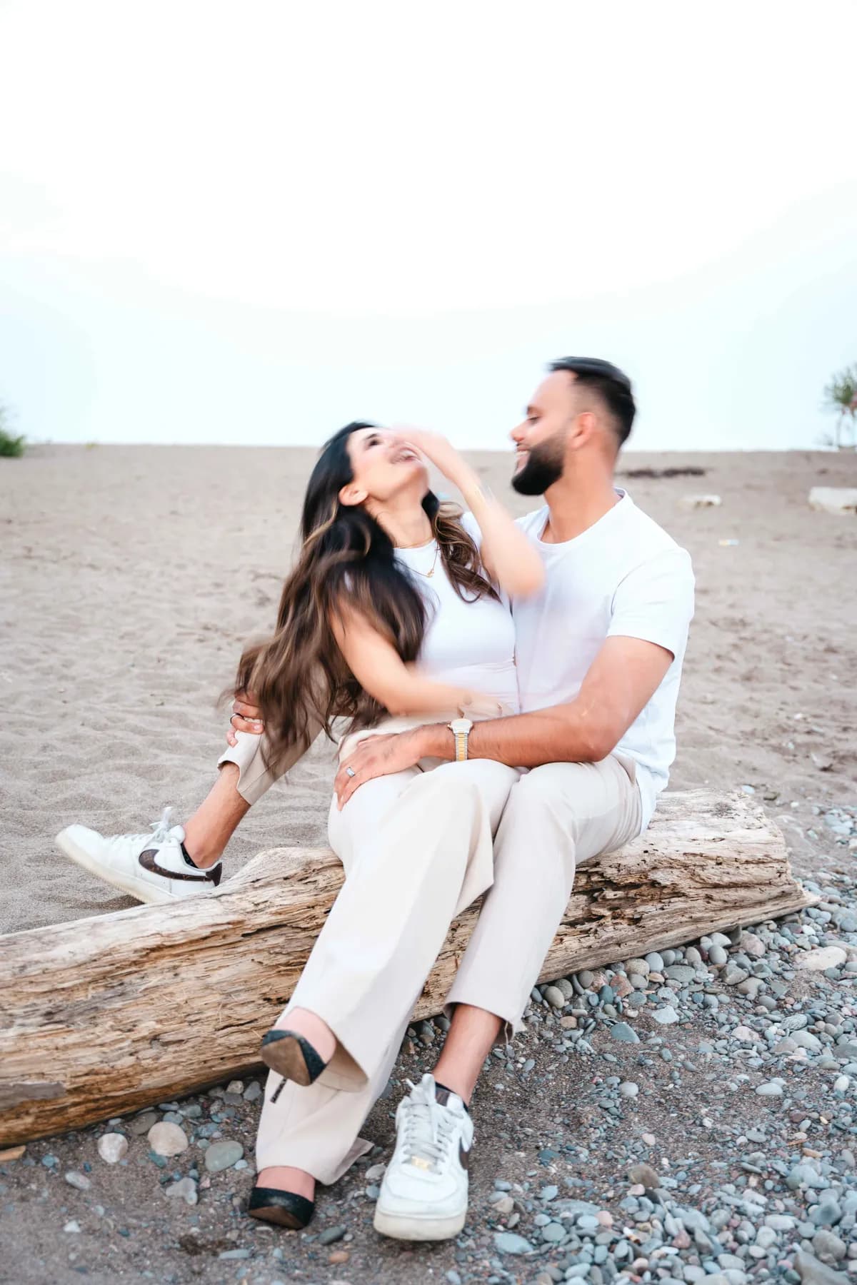 The couple seated together on the beach at A and F’s couples session.
