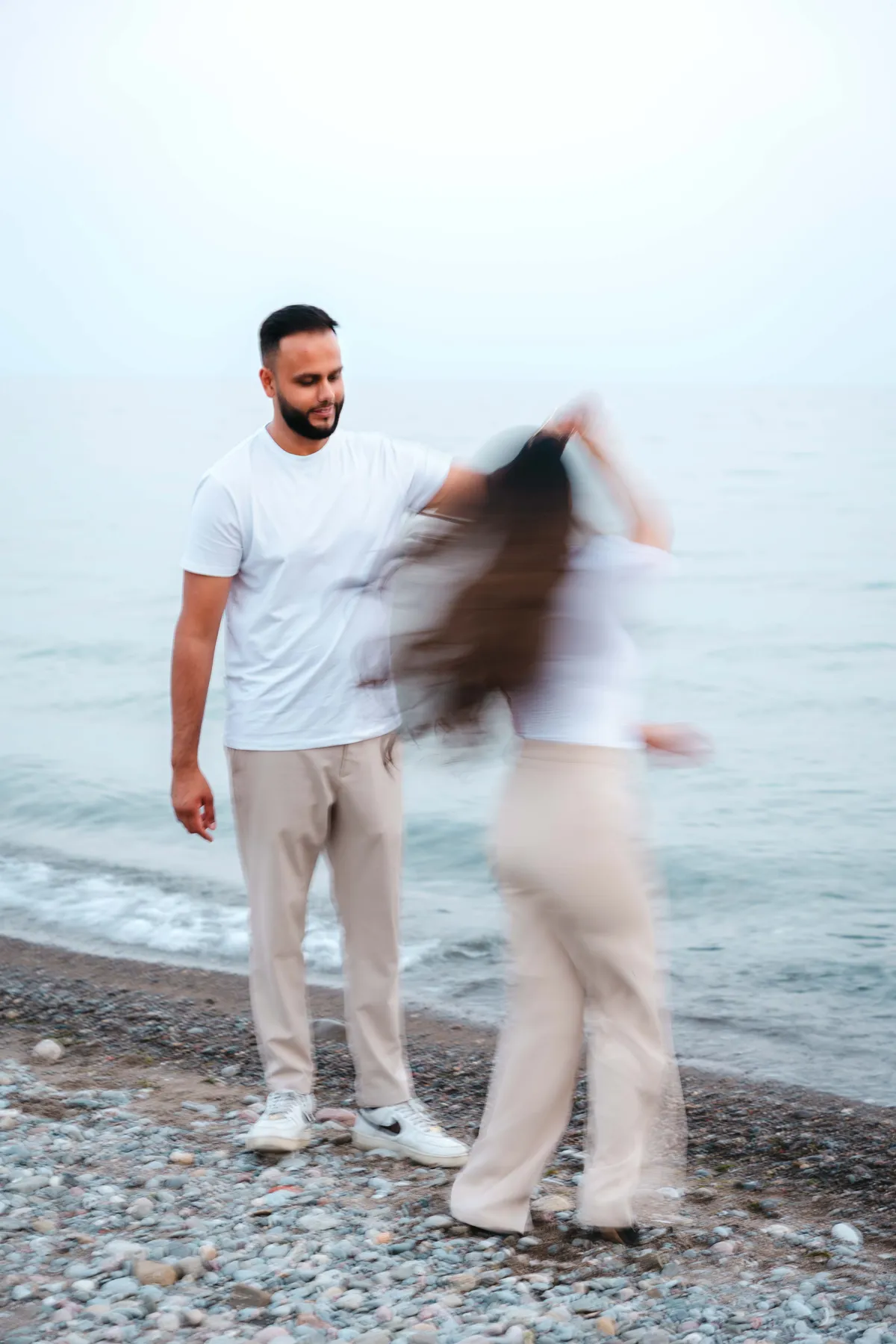 The couple twirling beside the water at A and F’s couples session.