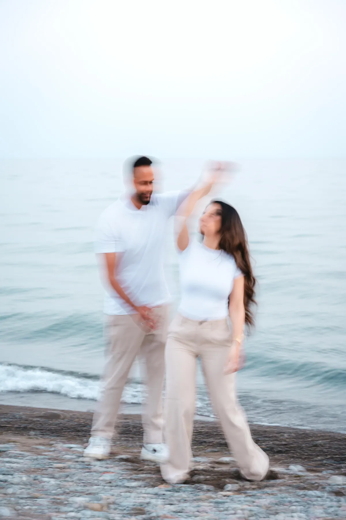 The couple twirling beside the water at A and F’s couples session.