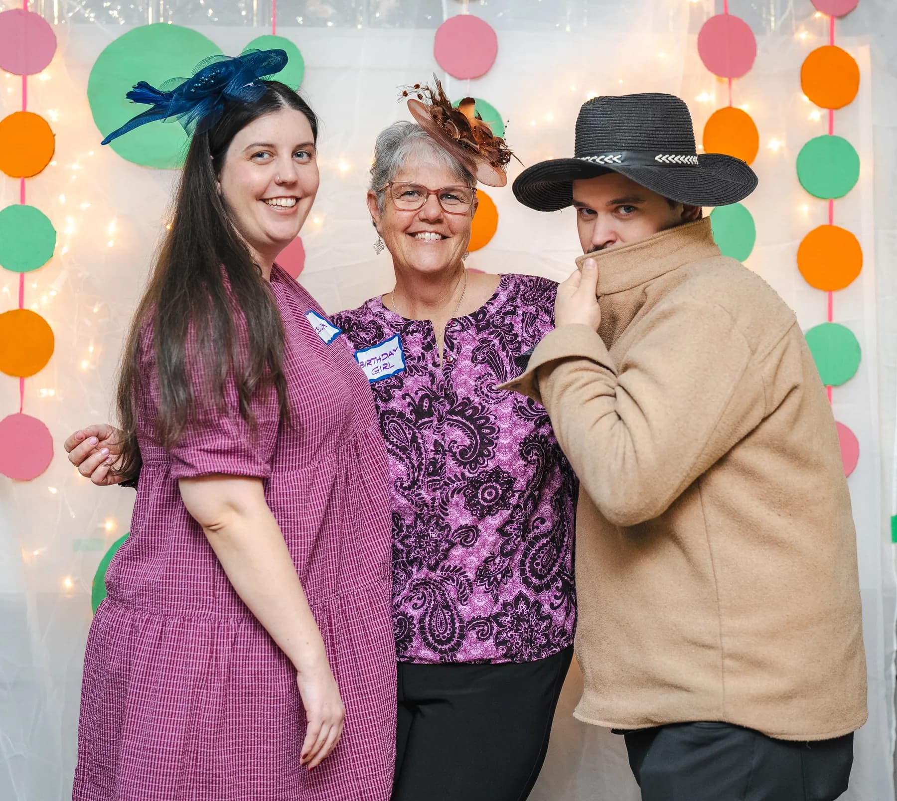 Guests posing in playful hats at Alison’s birthday celebration.