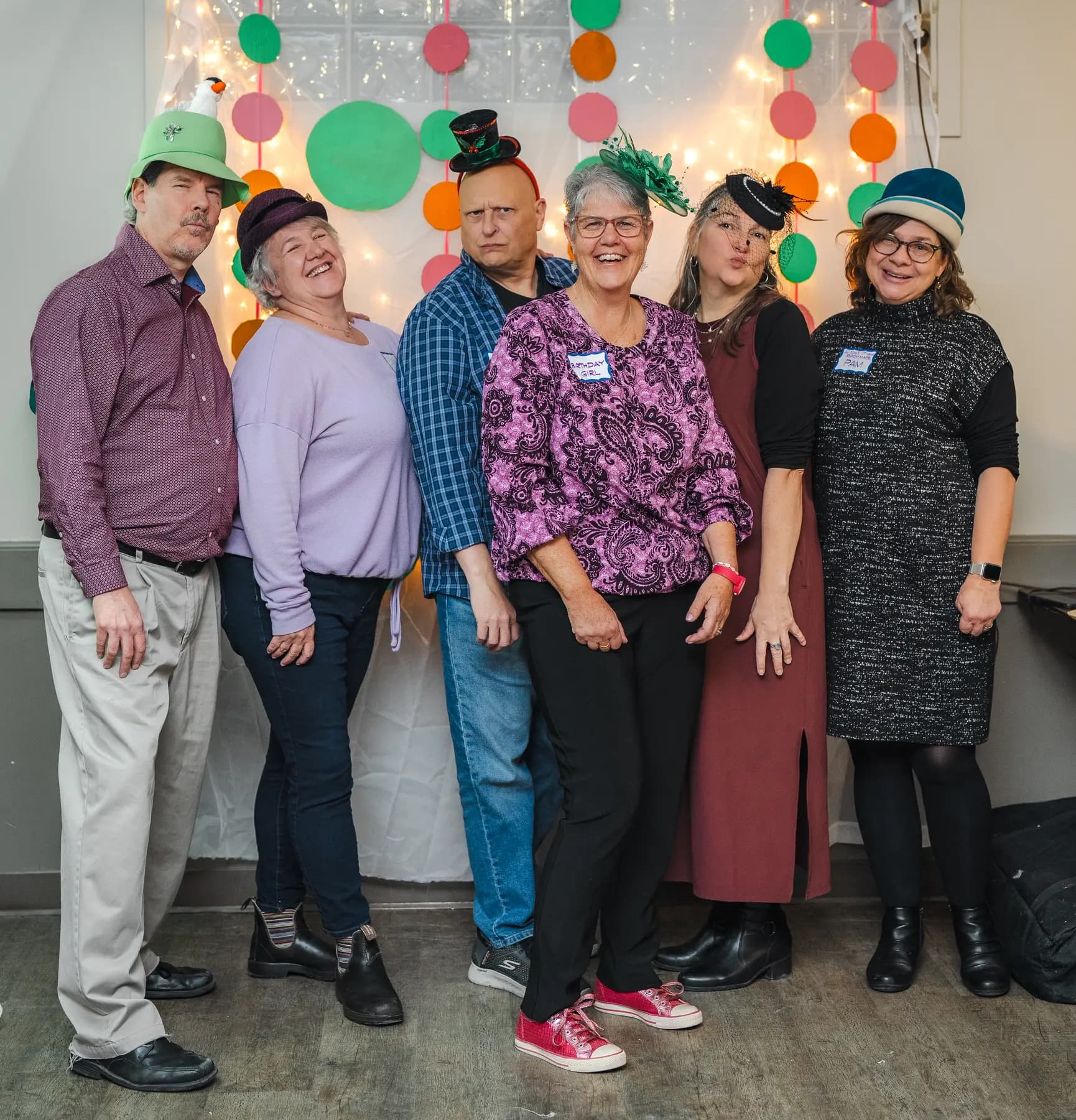 Guests posing in playful hats at Alison’s birthday celebration.