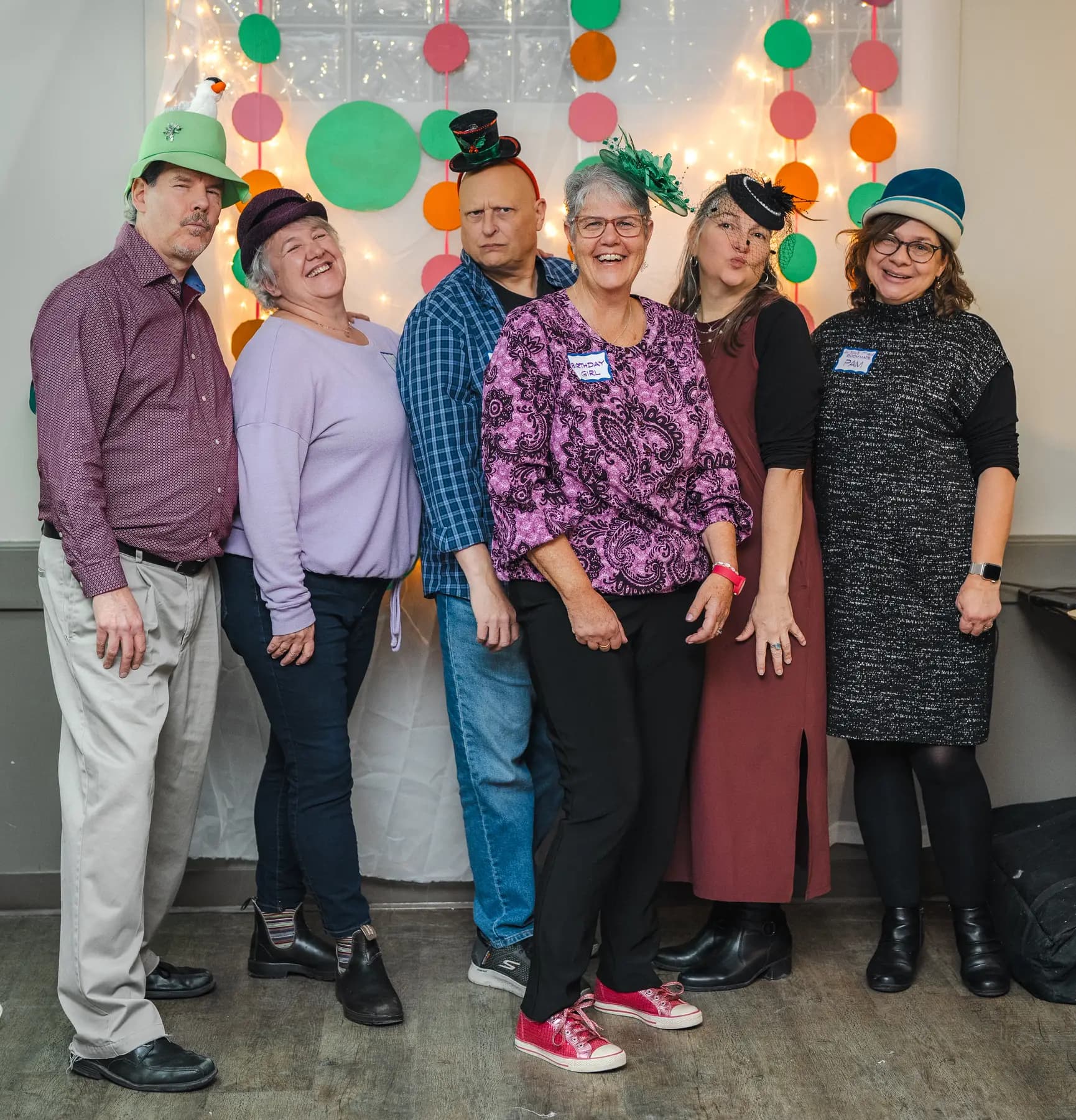 Guests posing in playful hats at Alison’s birthday celebration.