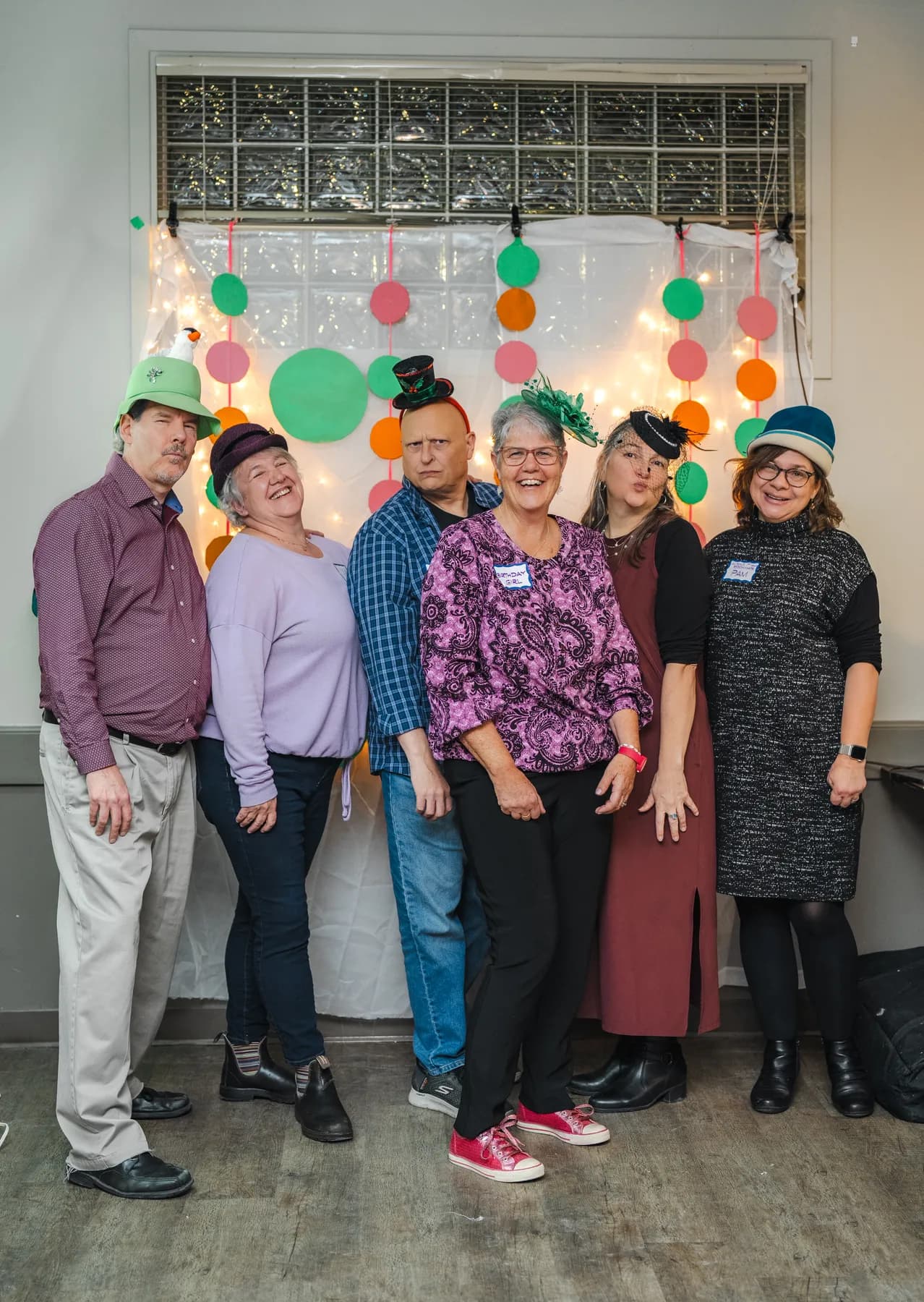 Guests posing in playful hats at Alison’s birthday celebration.