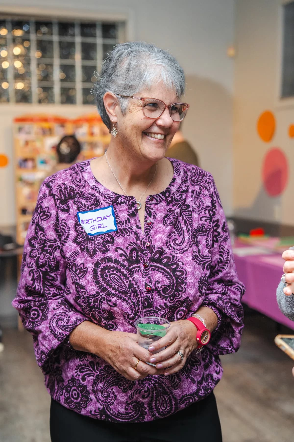 A woman smiling at Alison’s birthday celebration.