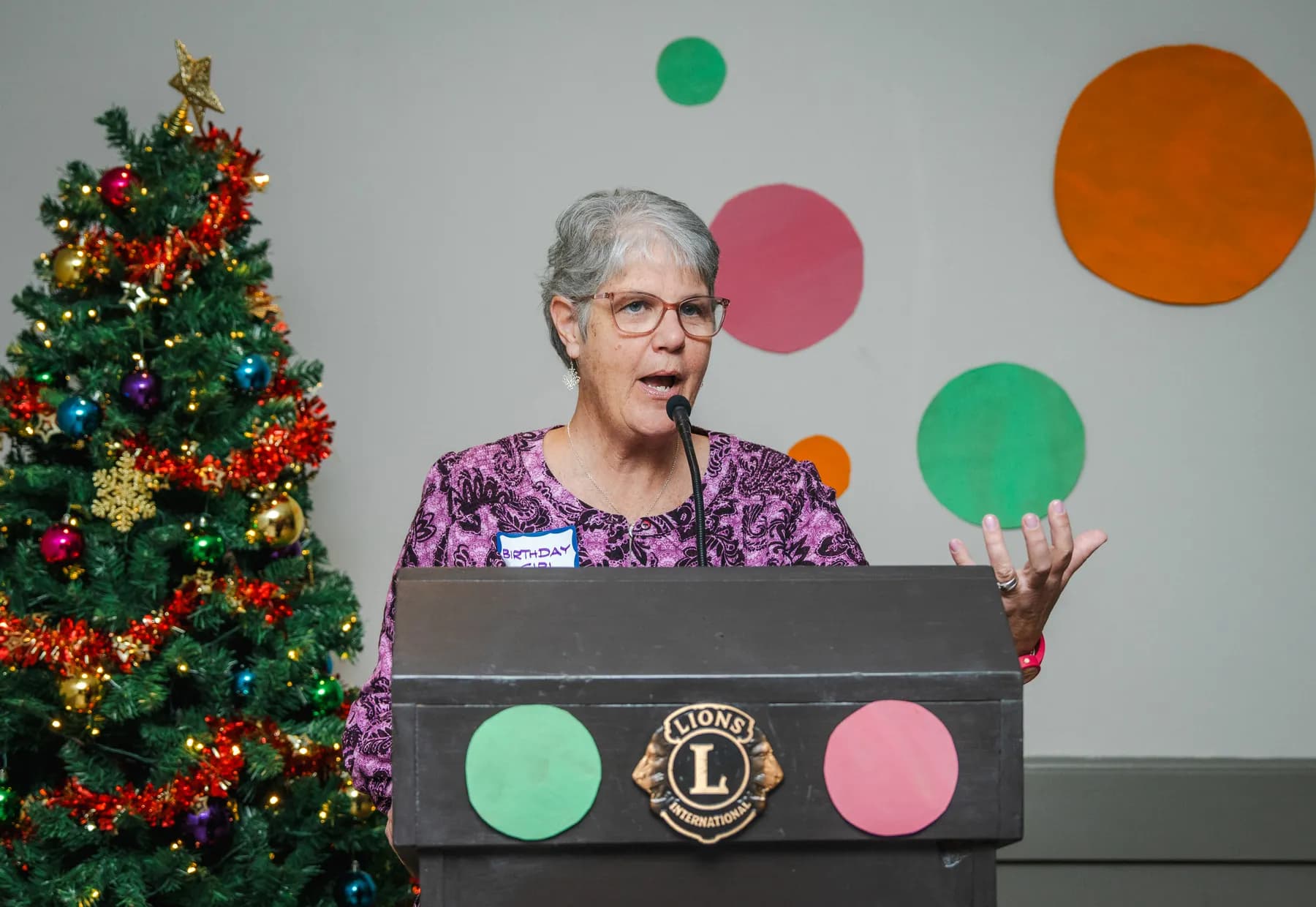 A woman speaking at the lectern at Alison’s birthday celebration.