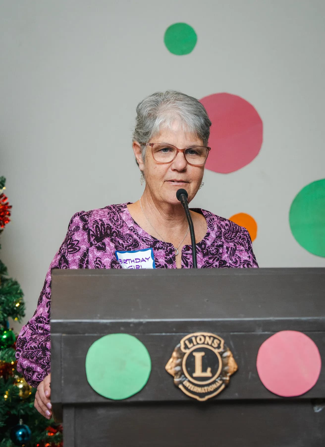 A woman speaking at the lectern at Alison’s birthday celebration.