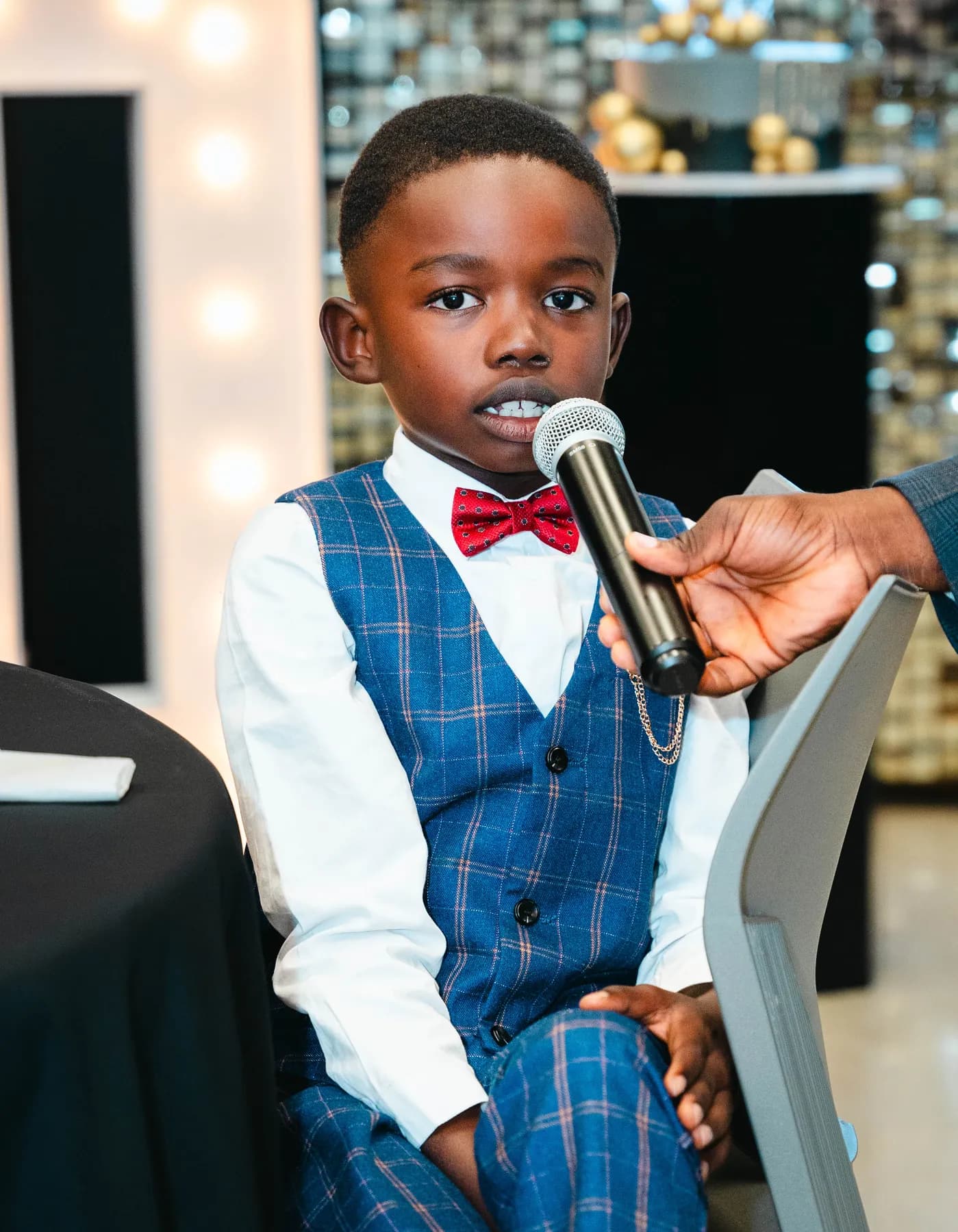 A child speaking into a microphone at BJ’s 40th birthday party.