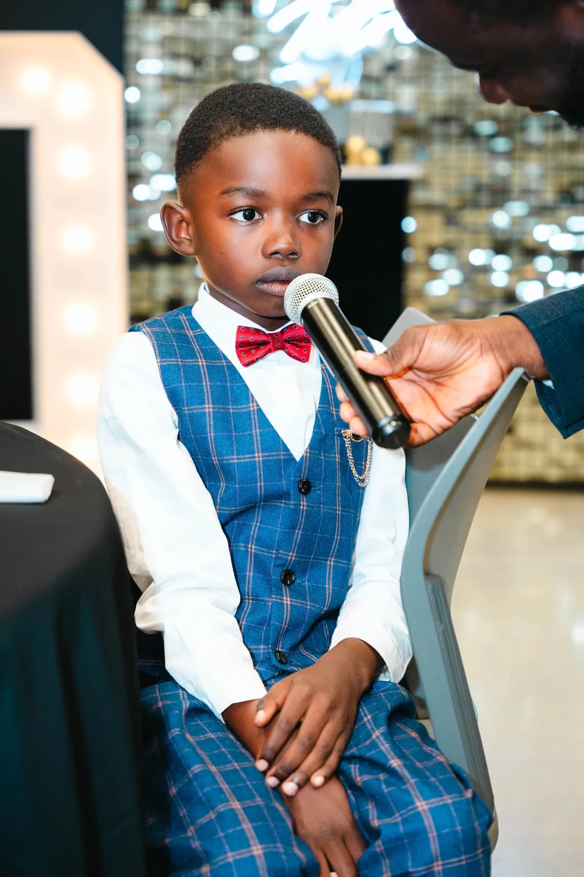 A child speaking into a microphone at BJ’s 40th birthday party.