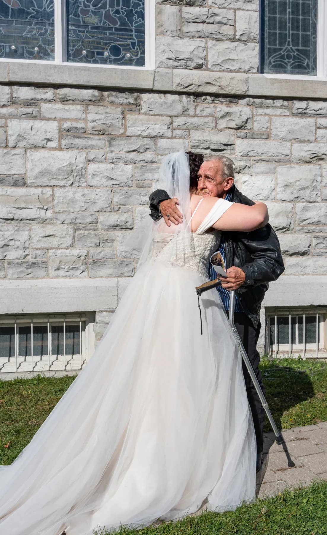 The bride posing with a male guest outside the church at Kody and Jaz’s wedding.