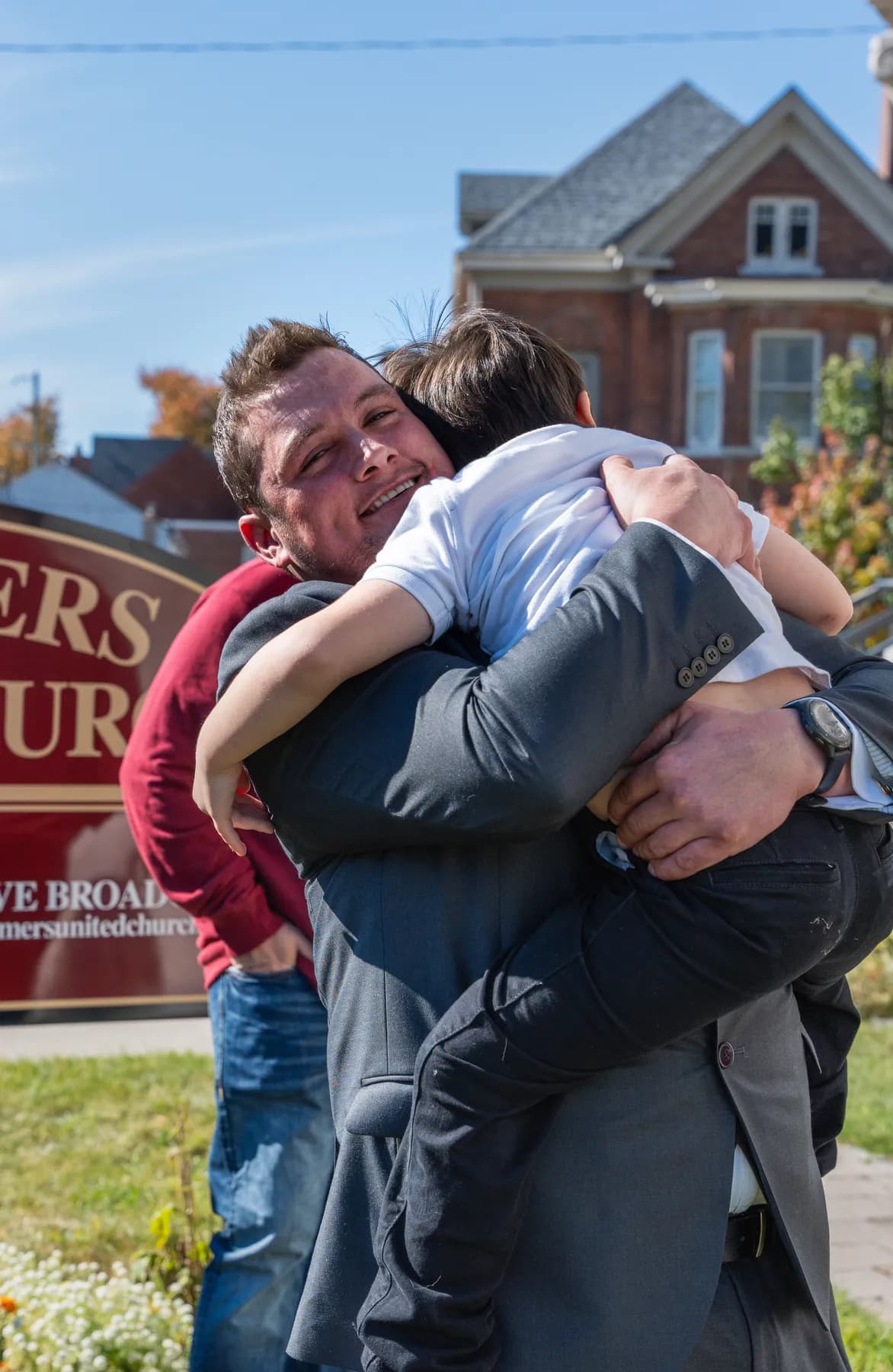 Guests hugging outside the church at Kody and Jaz’s wedding.