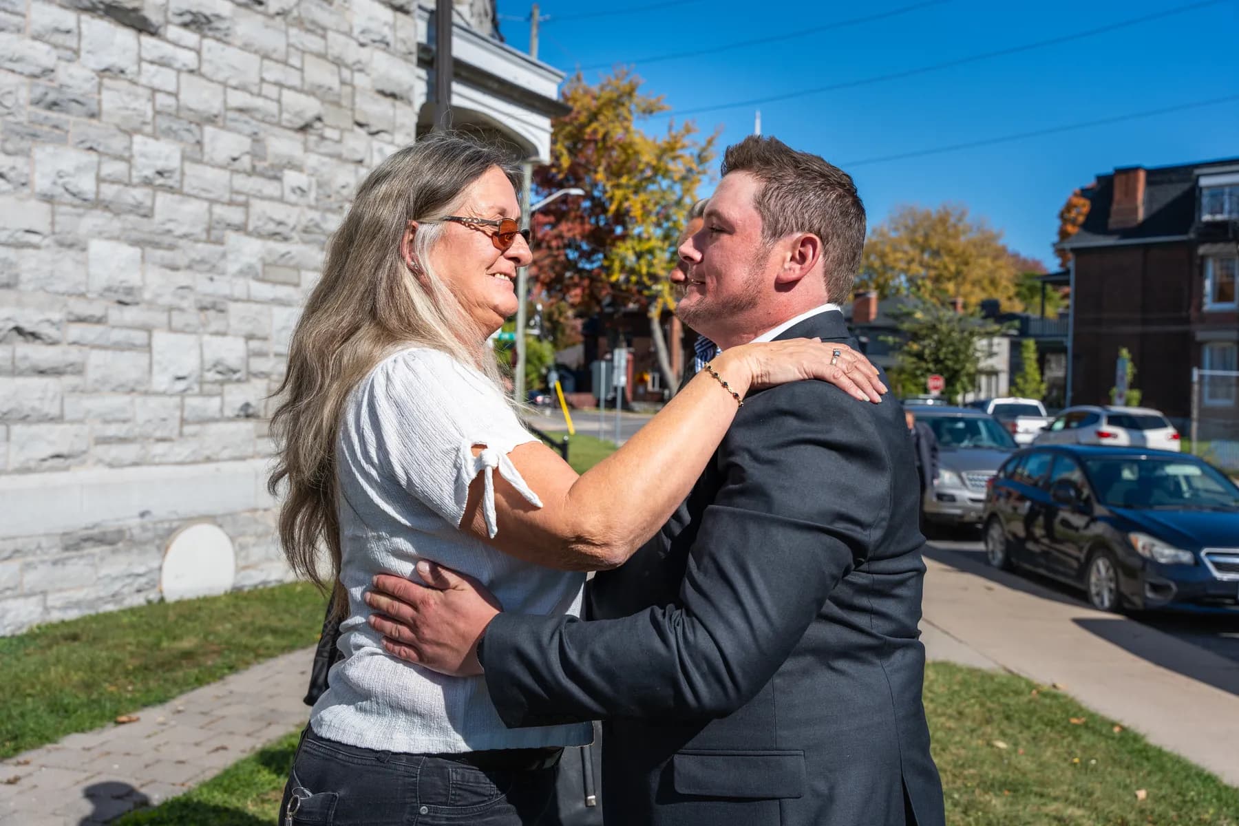 Guests hugging outside the church at Kody and Jaz’s wedding.
