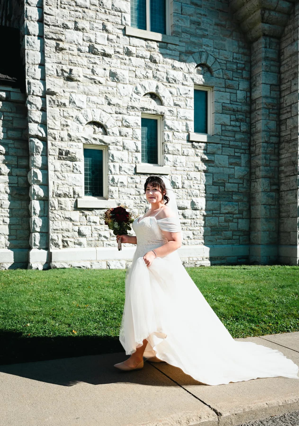 The bride posing beside the church at Kody and Jaz’s wedding.