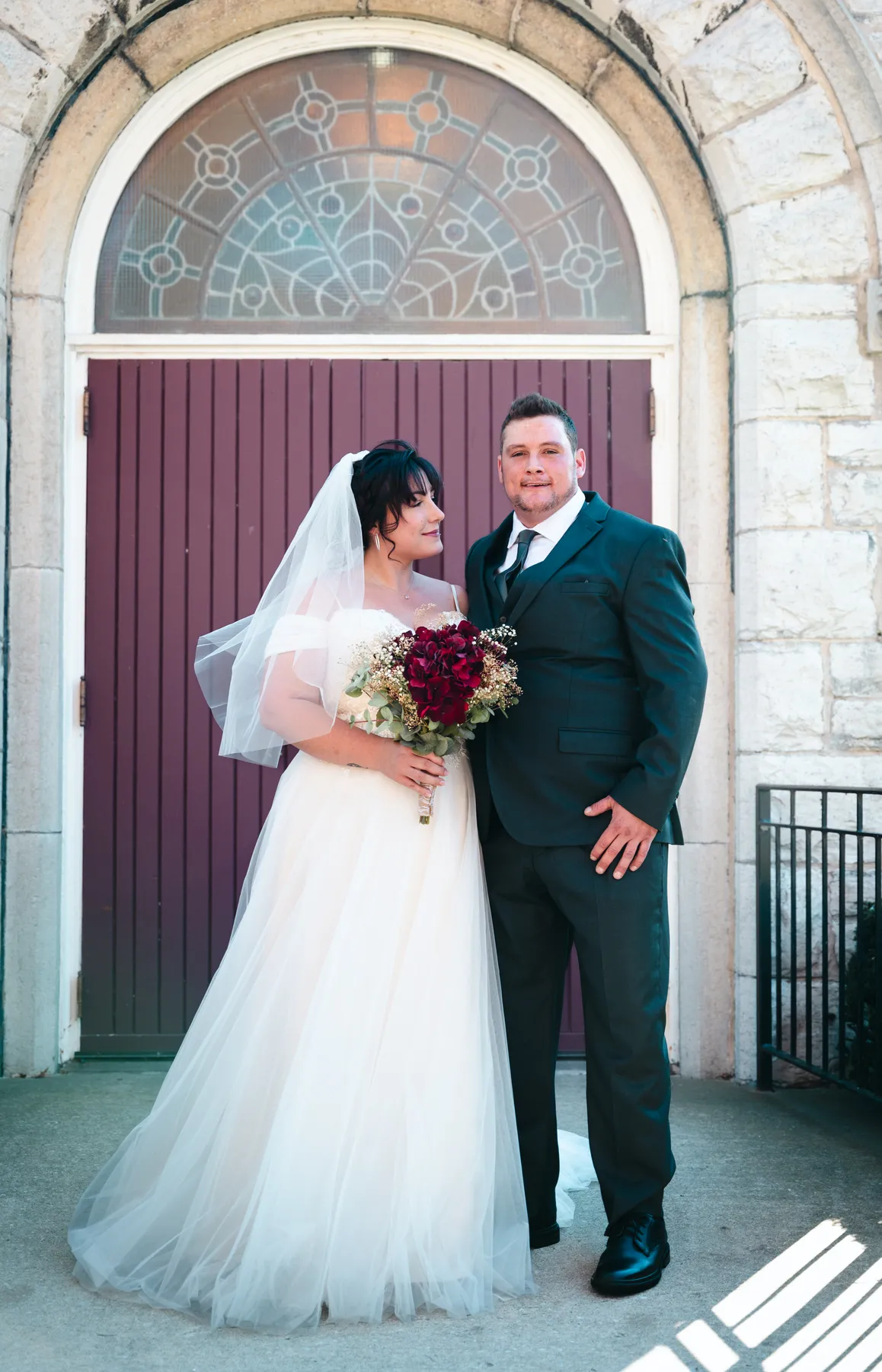 The couple embracing at the church door at Kody and Jaz’s wedding.