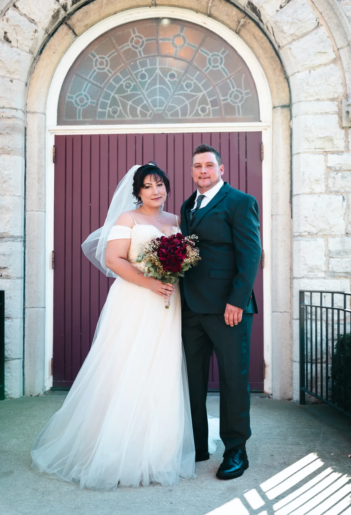 The couple embracing at the church door at Kody and Jaz’s wedding.