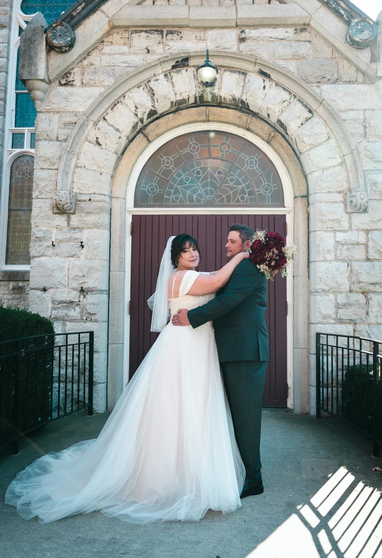 The couple embracing at the church door at Kody and Jaz’s wedding.