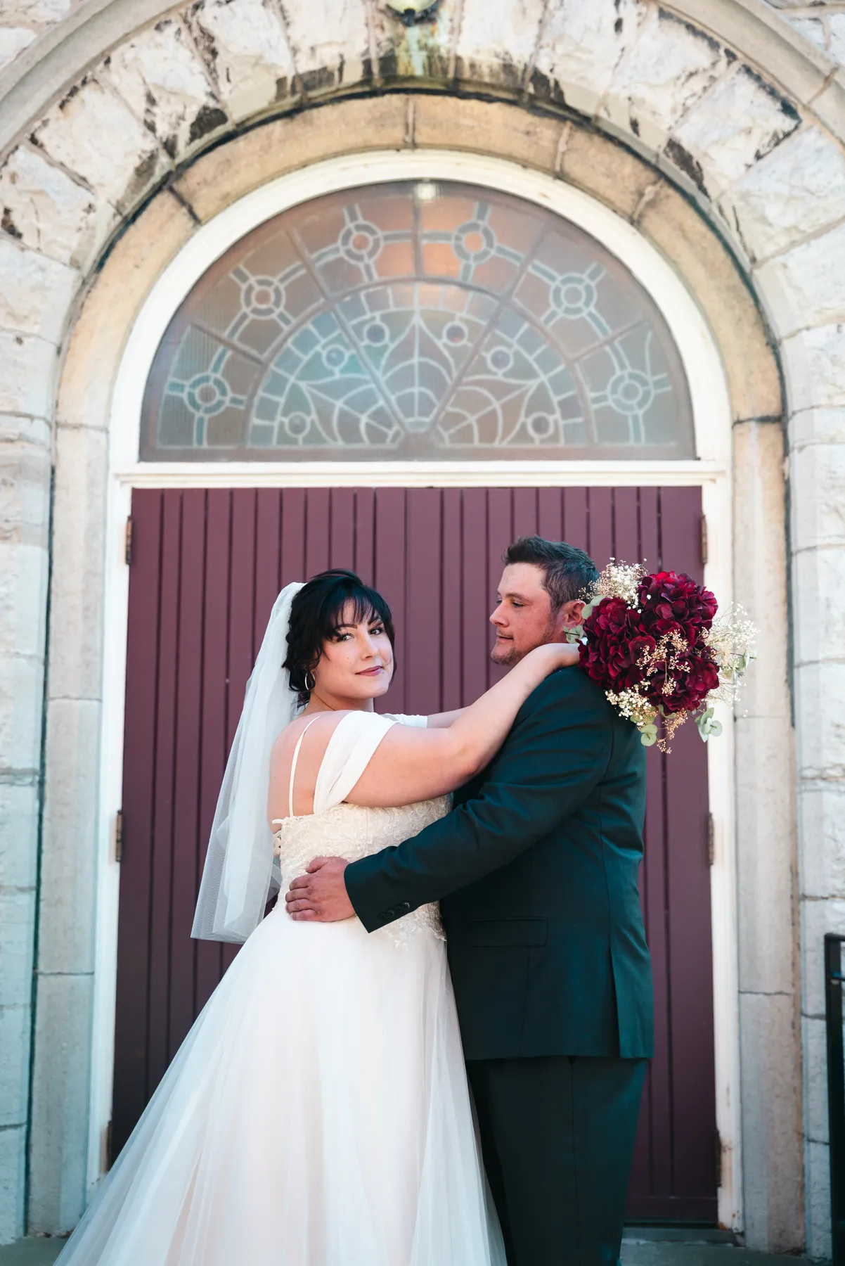 The couple embracing at the church door at Kody and Jaz’s wedding.