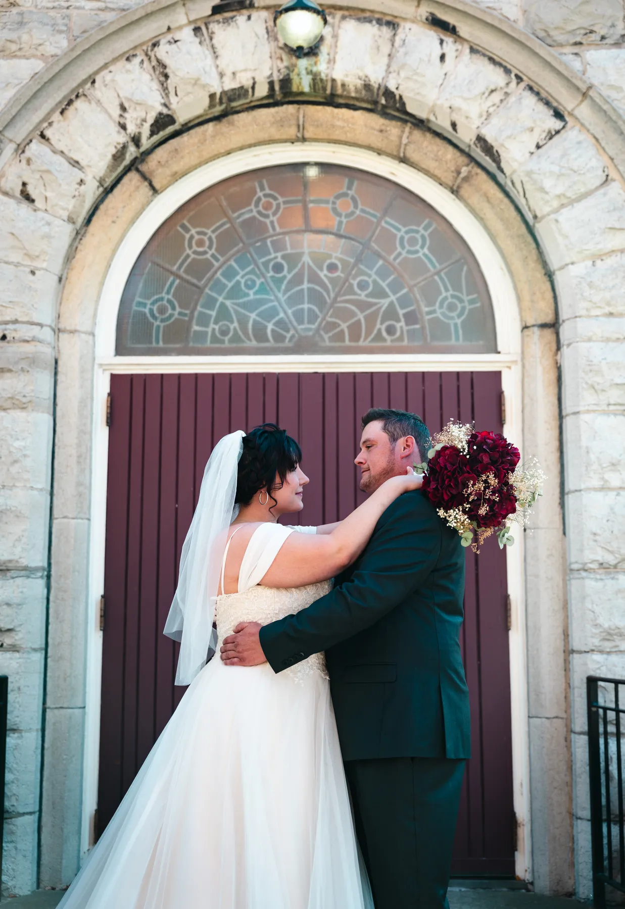 The couple embracing at the church door at Kody and Jaz’s wedding.