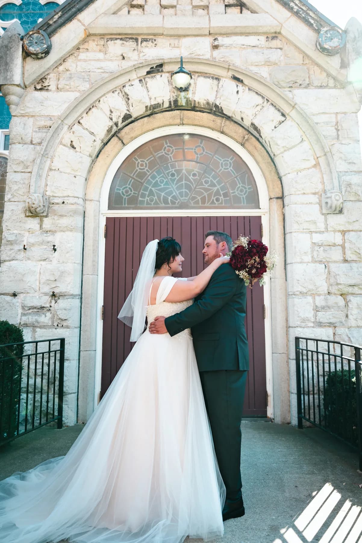 The couple embracing at the church door at Kody and Jaz’s wedding.