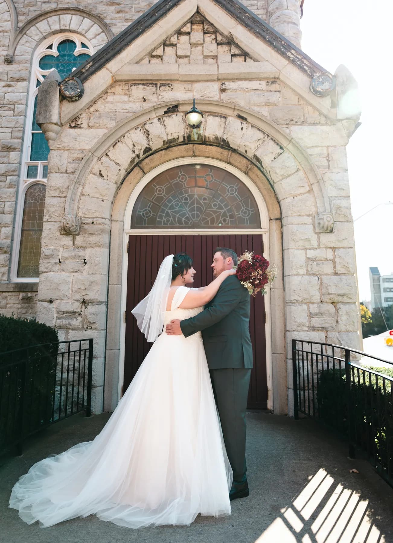 The couple embracing at the church door at Kody and Jaz’s wedding.