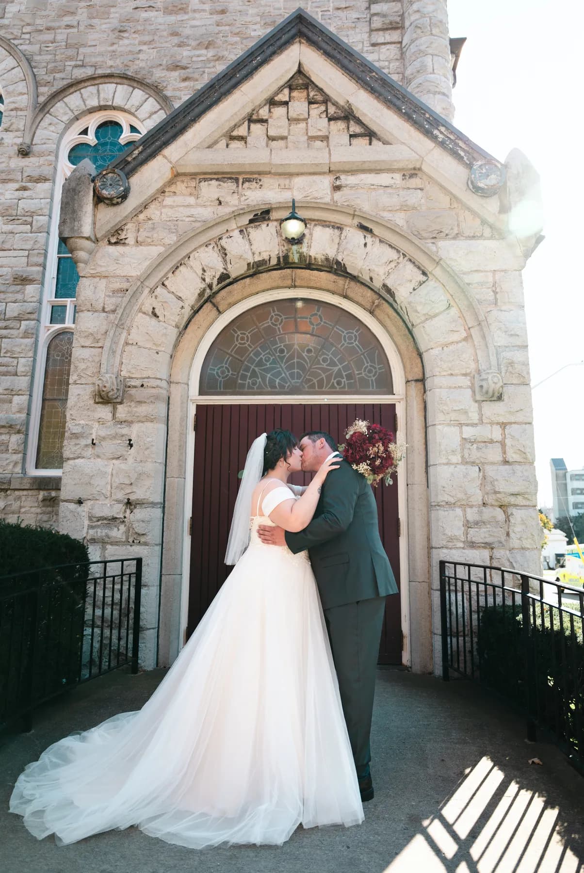 The couple embracing at the church door at Kody and Jaz’s wedding.