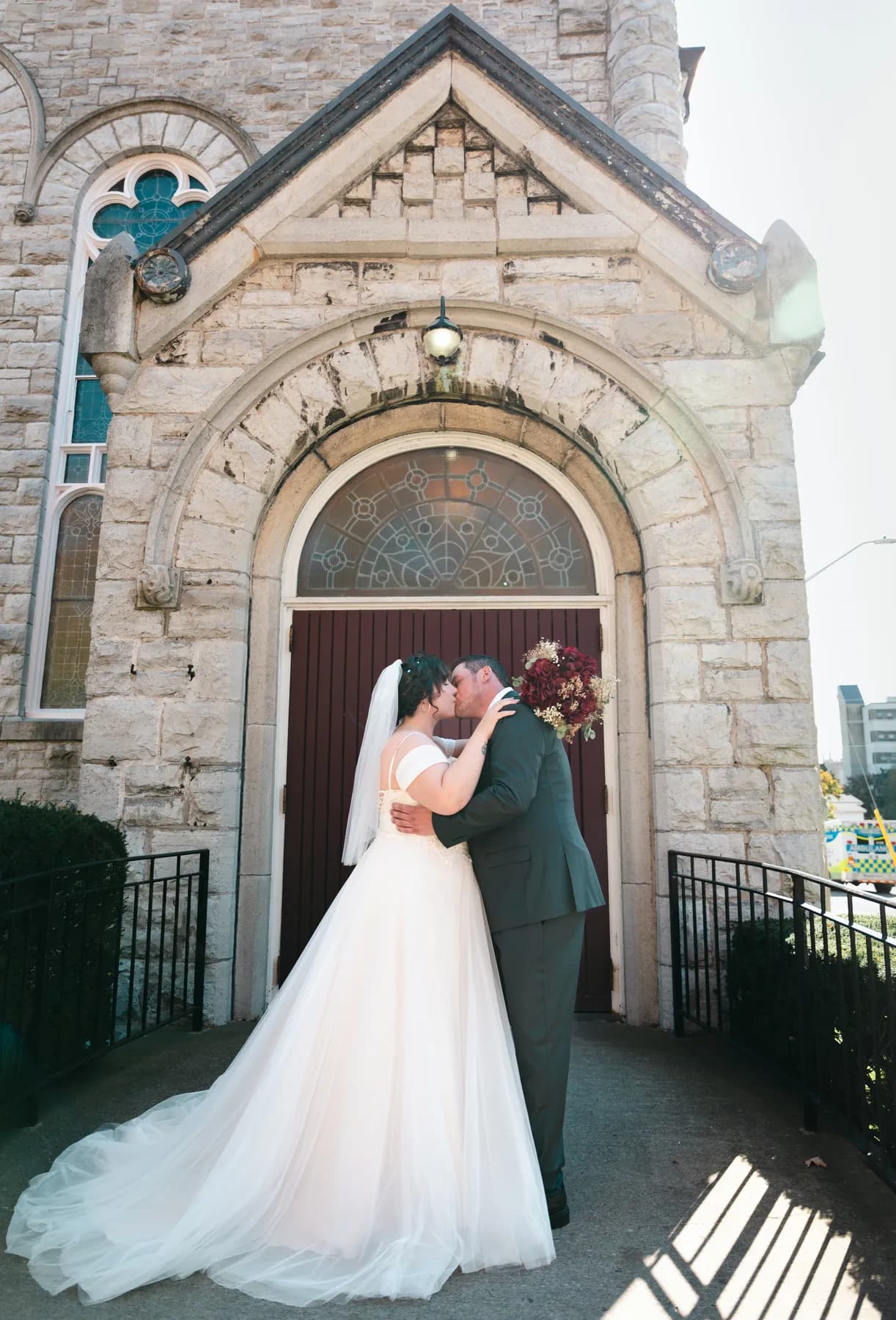 The couple embracing at the church door at Kody and Jaz’s wedding.