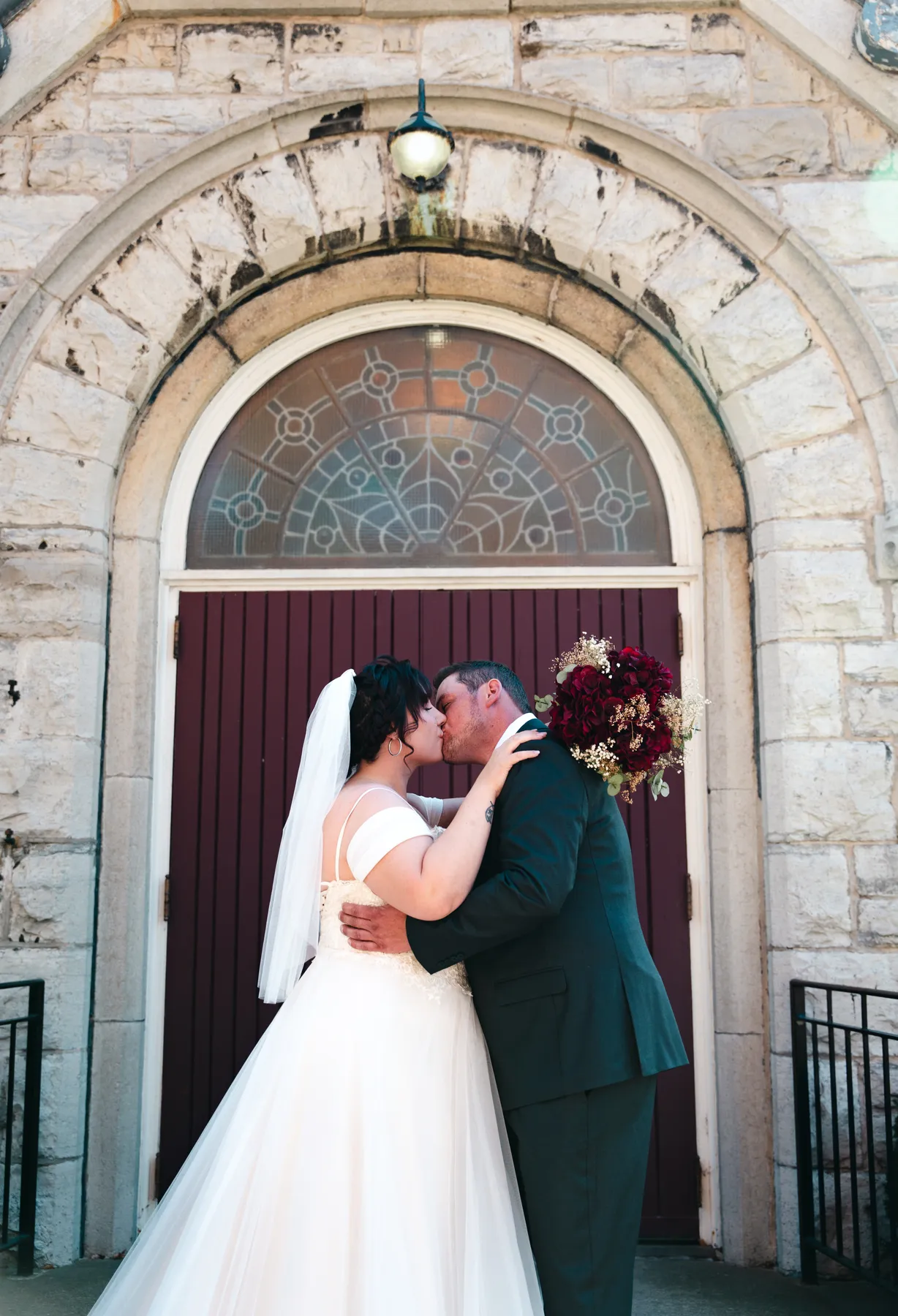The couple embracing at the church door at Kody and Jaz’s wedding.