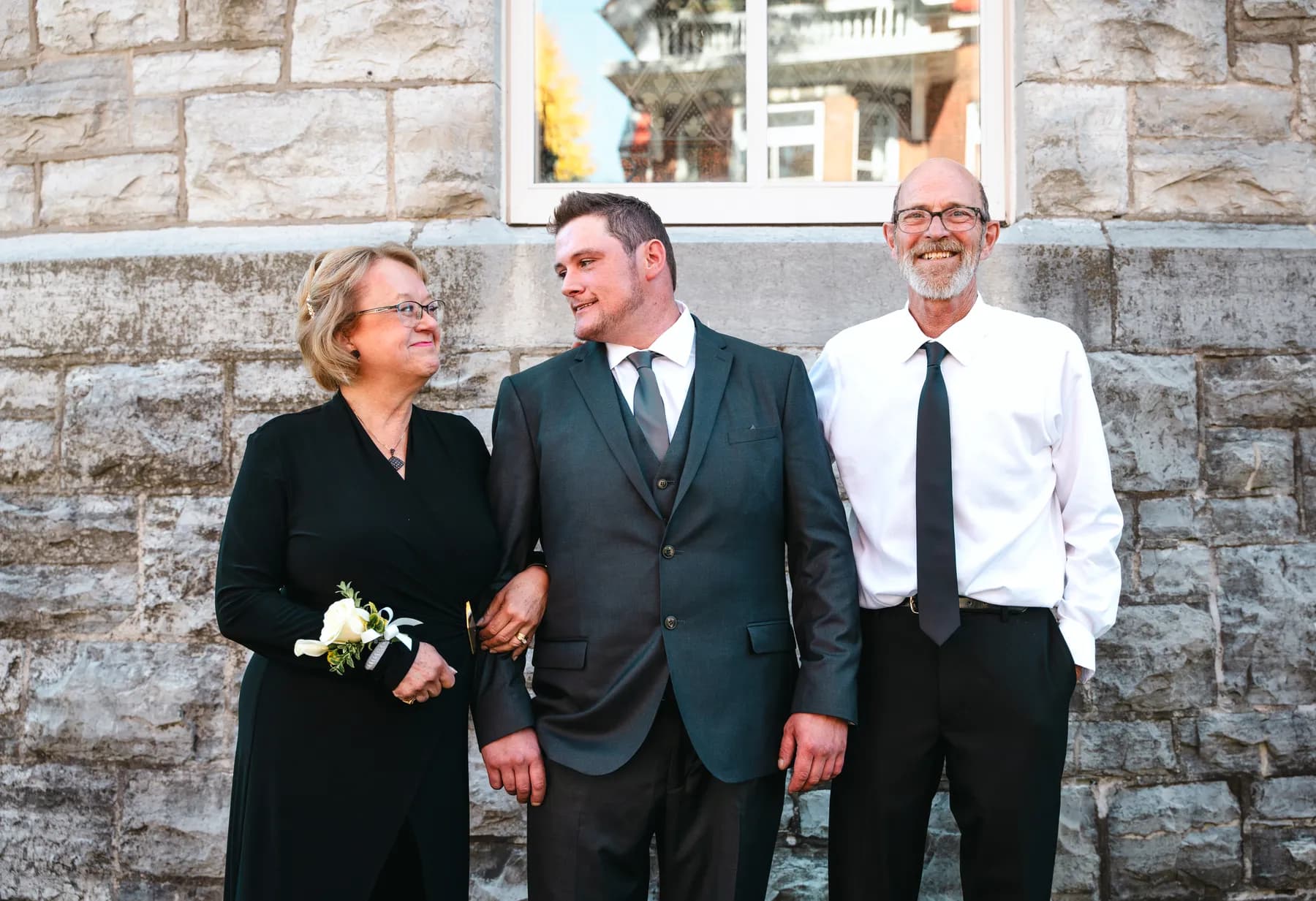 The groom posing with male guests outside the church at Kody and Jaz’s wedding.