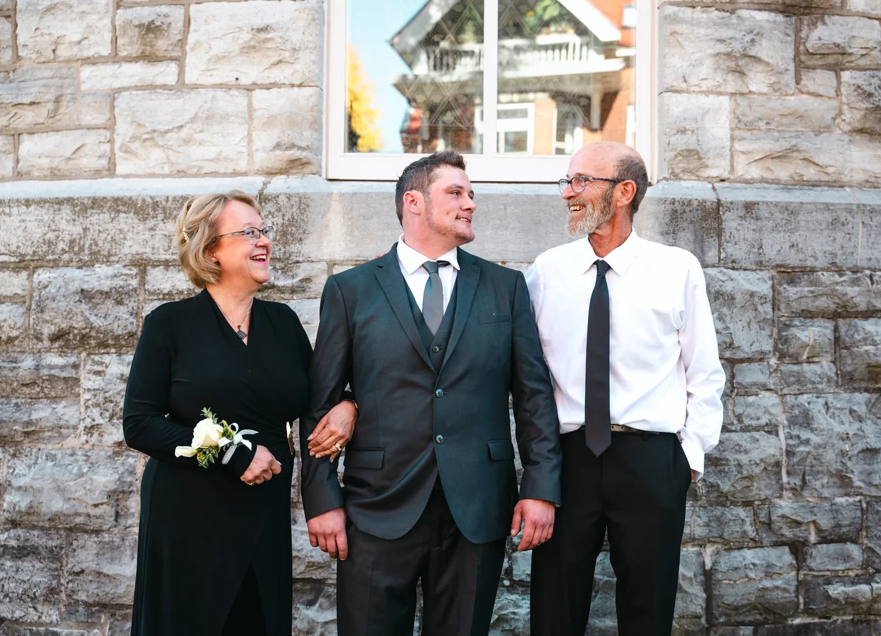 The groom posing with male guests outside the church at Kody and Jaz’s wedding.