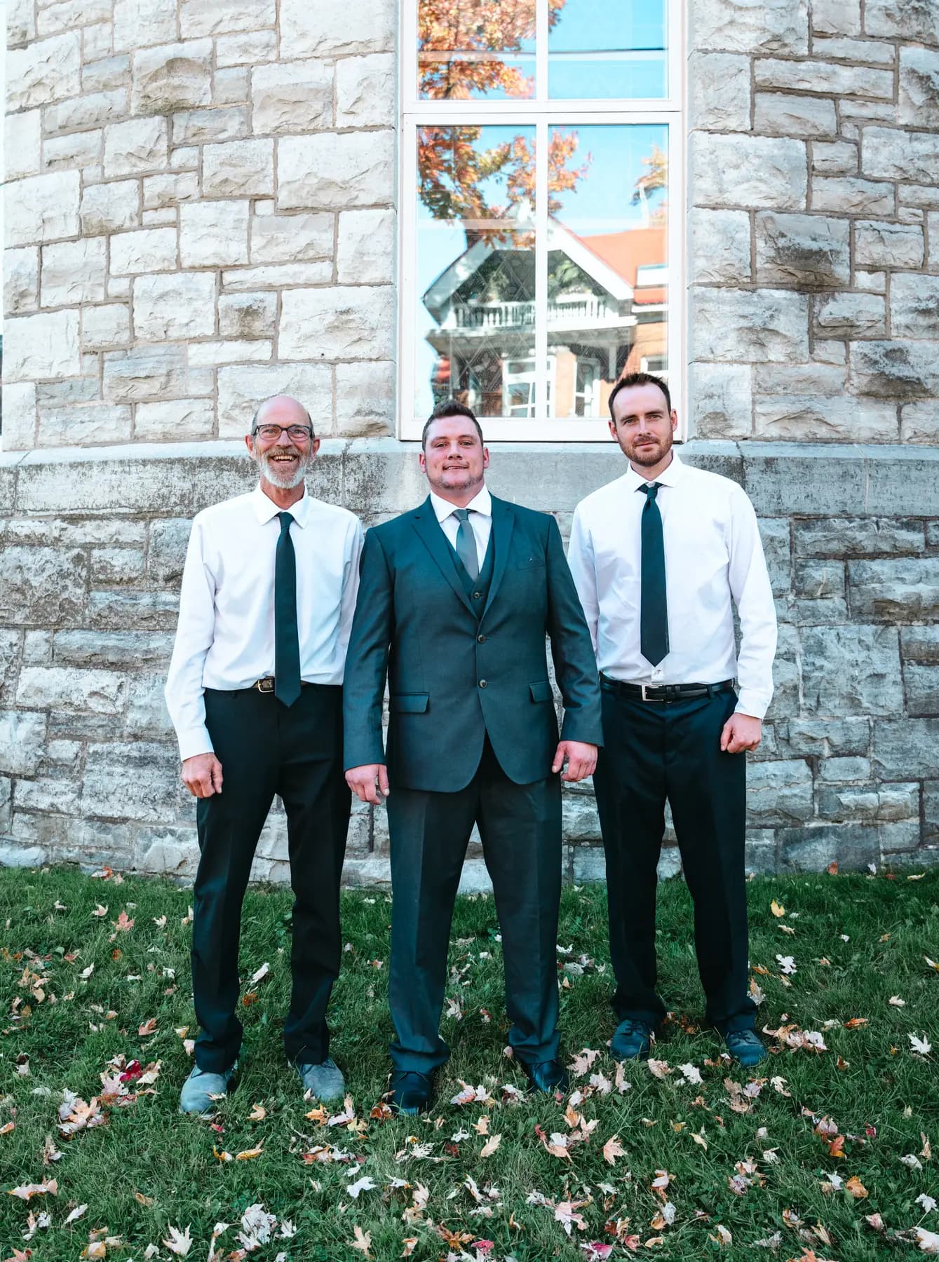 The groom posing with male guests outside the church at Kody and Jaz’s wedding.