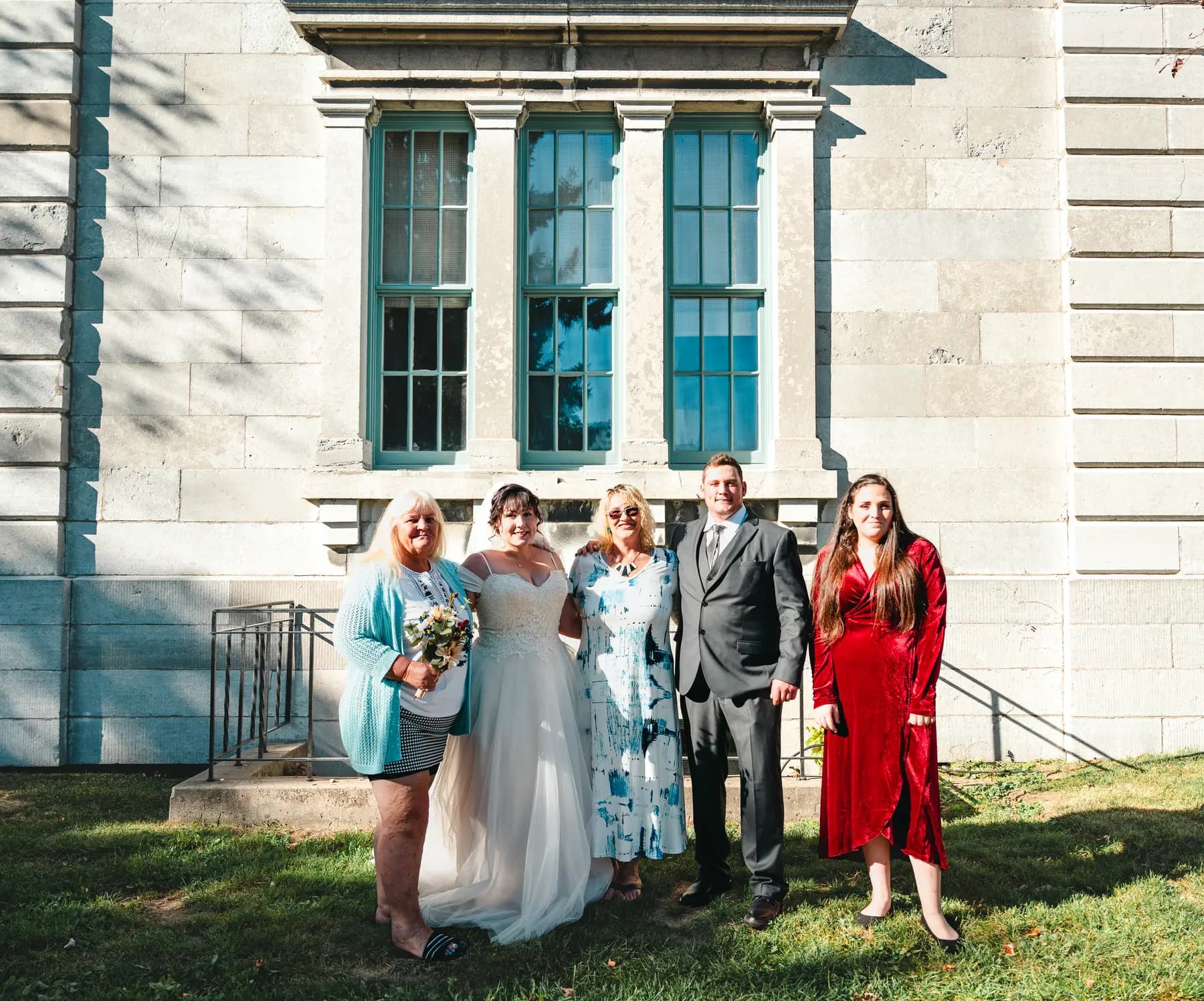 The couple with guests outside a stone building at Kody and Jaz’s wedding.