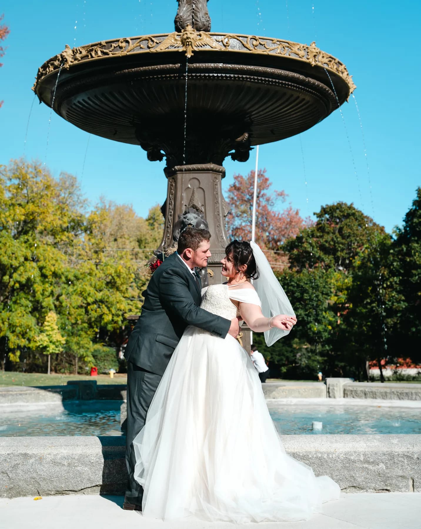 The couple posing by a large fountain at Kody and Jaz’s wedding.