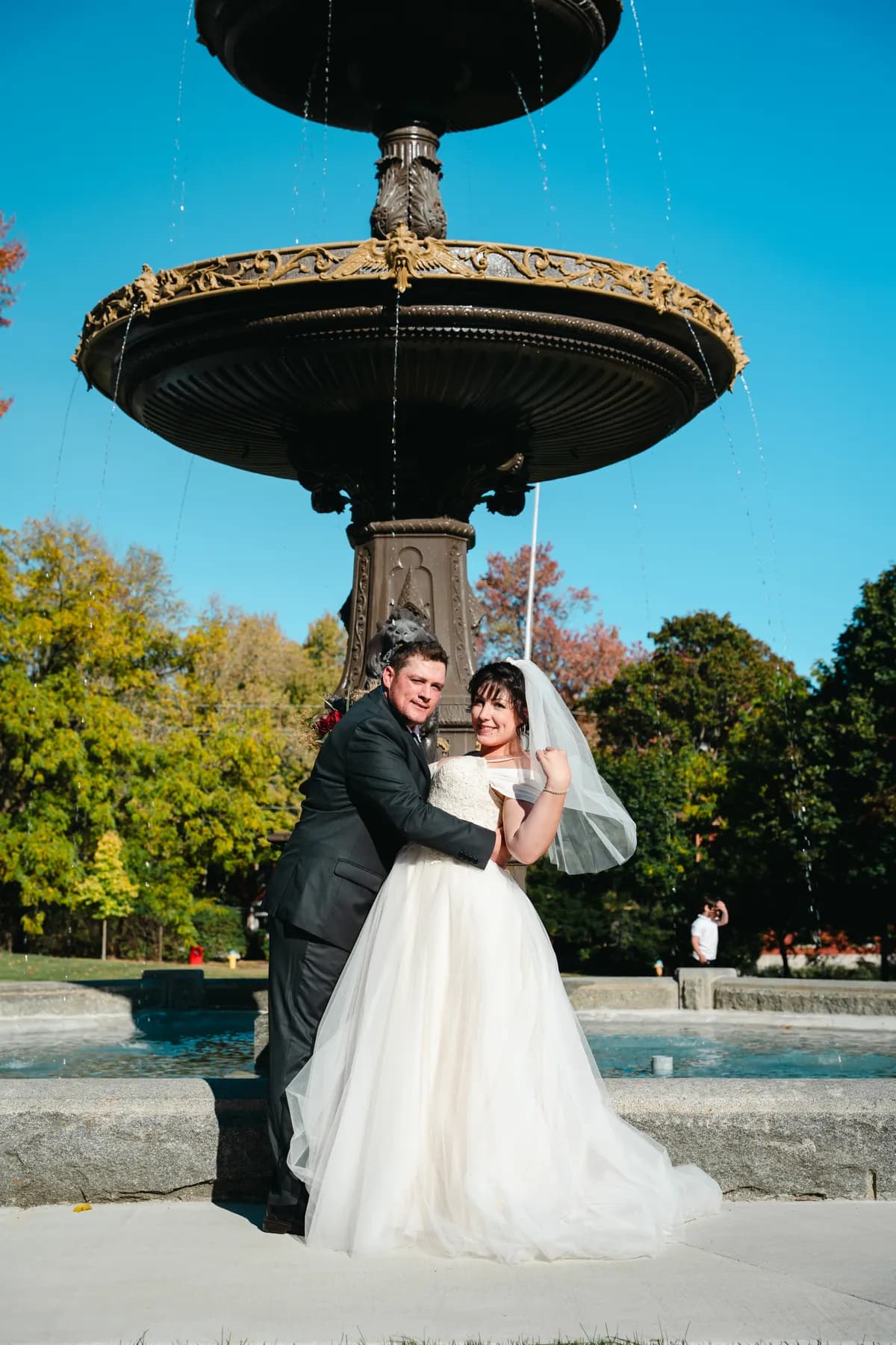 The couple posing by a large fountain at Kody and Jaz’s wedding.
