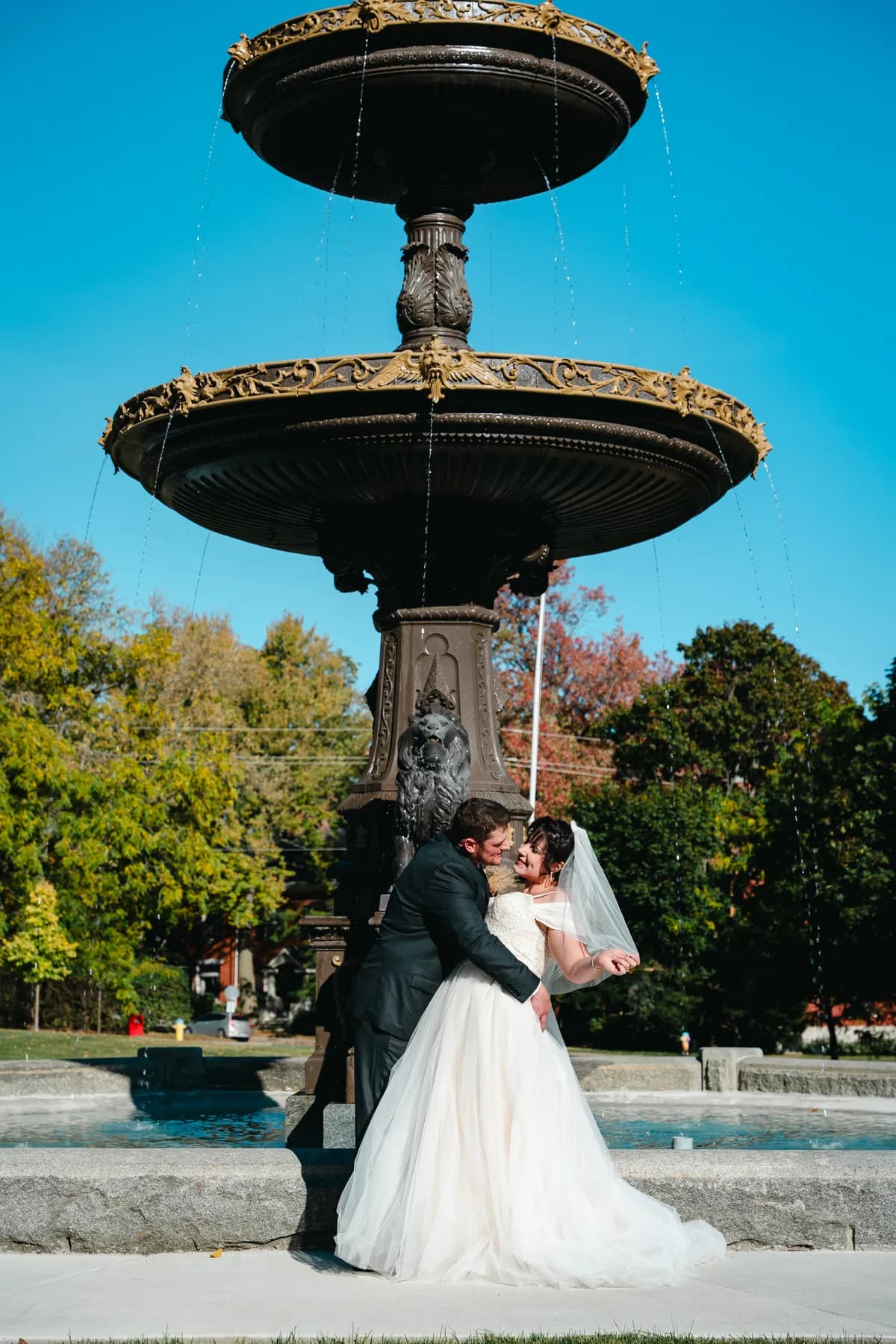 The couple posing by a large fountain at Kody and Jaz’s wedding.