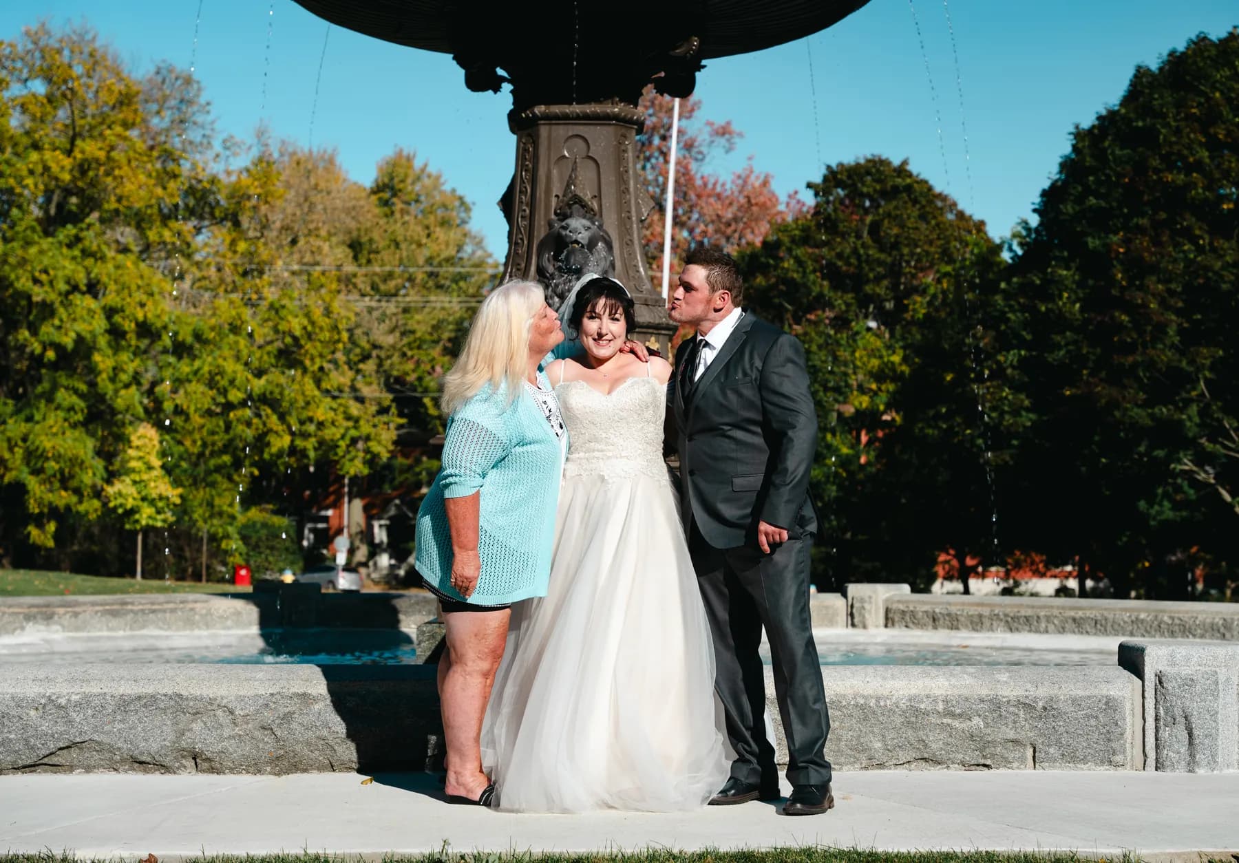 The couple with a female guest beside the fountain at Kody and Jaz’s wedding.