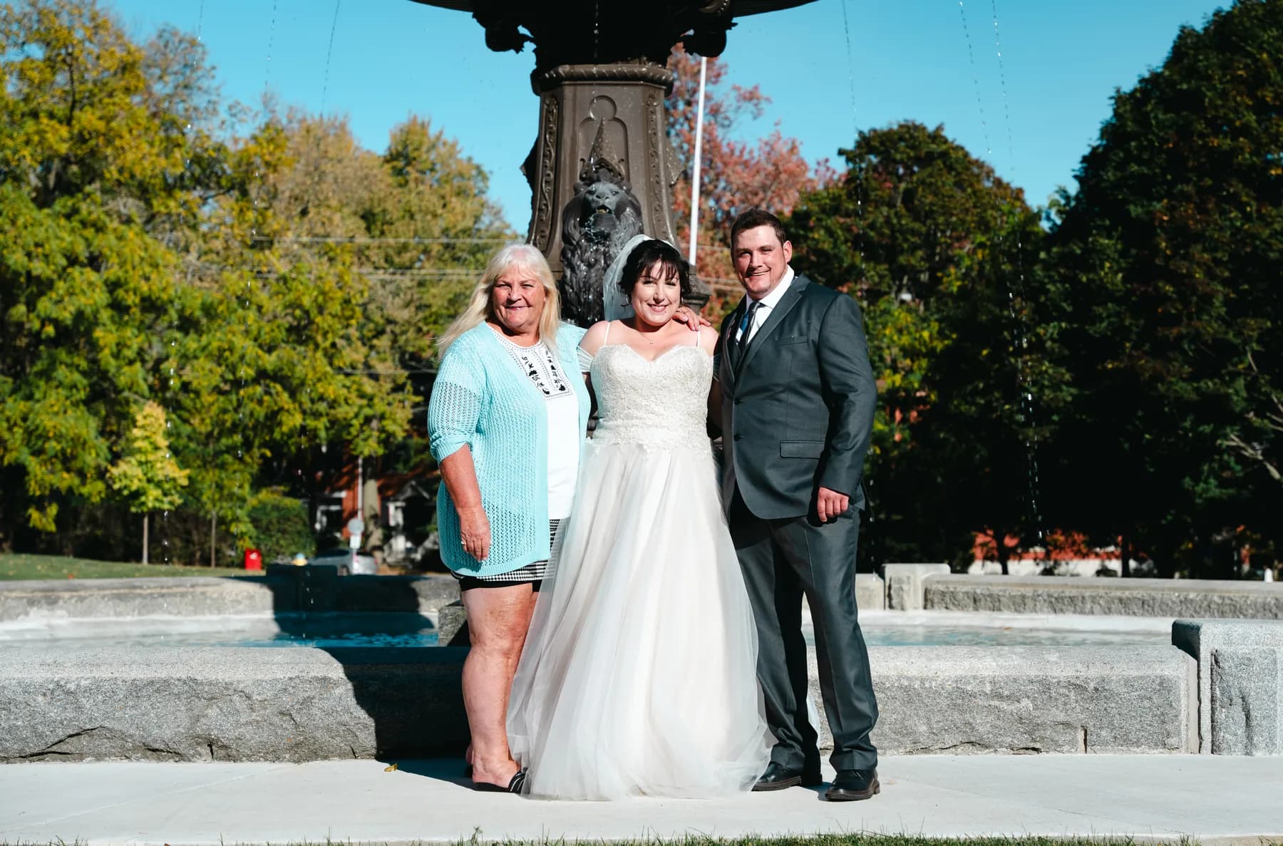 The couple with a female guest beside the fountain at Kody and Jaz’s wedding.