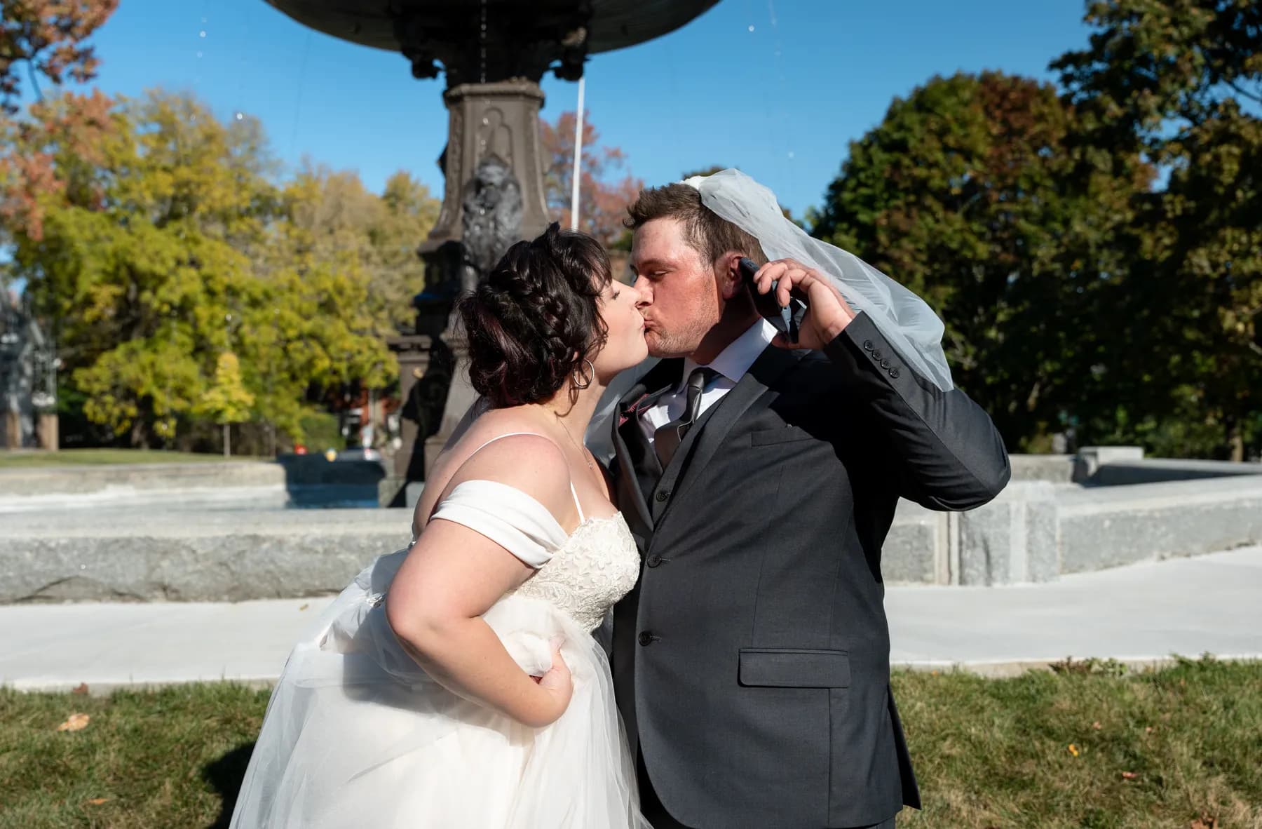 The couple sharing playful moments beside the fountain at Kody and Jaz’s wedding.