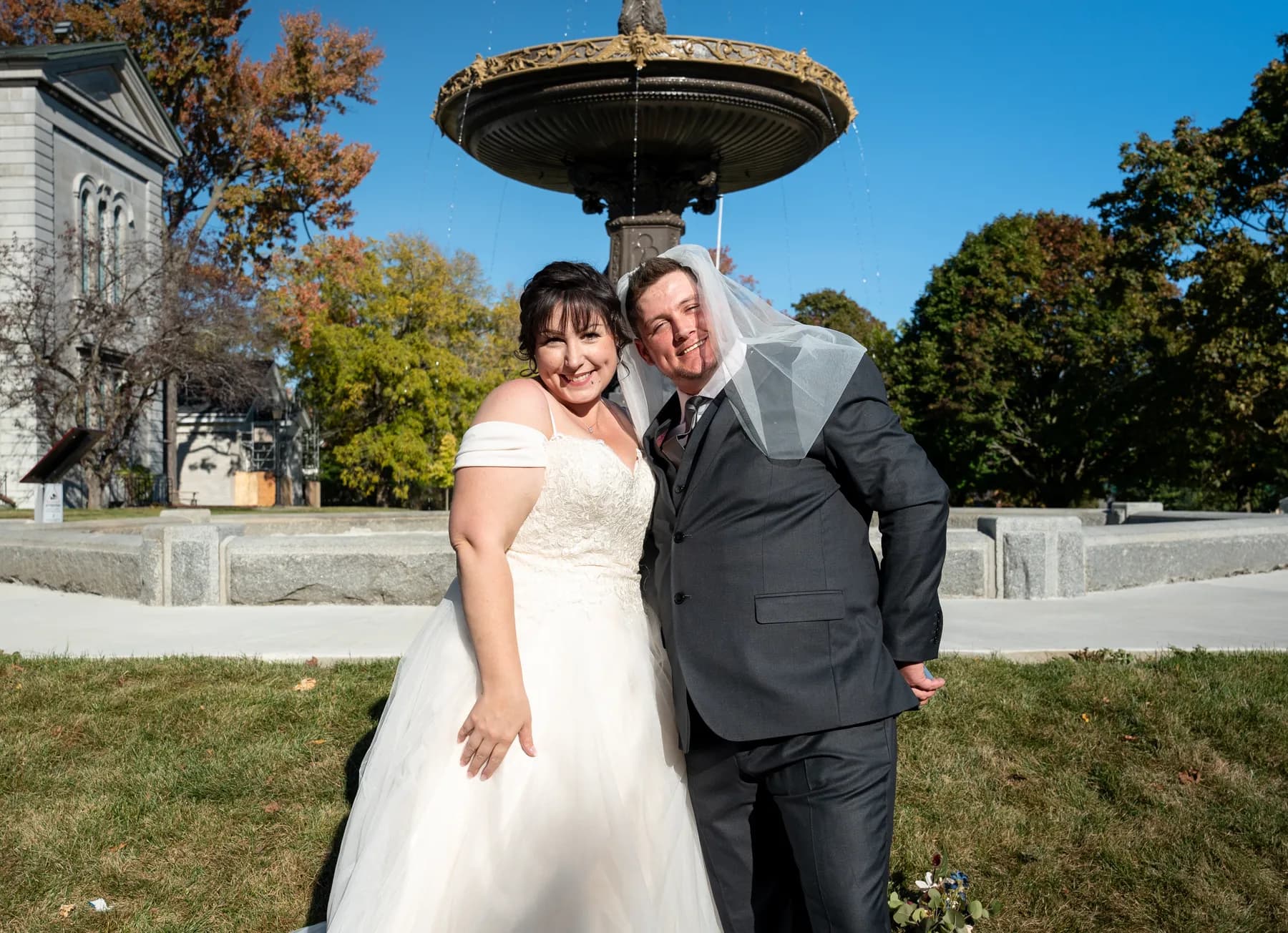 The couple sharing playful moments beside the fountain at Kody and Jaz’s wedding.
