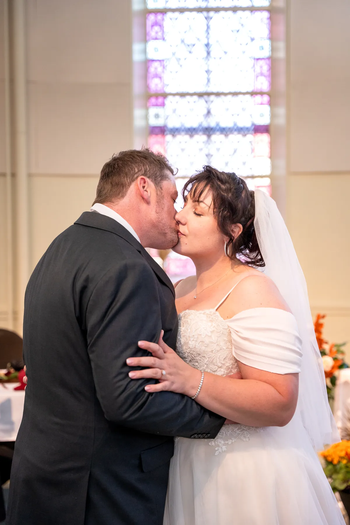 The couple embracing indoors at Kody and Jaz’s wedding.