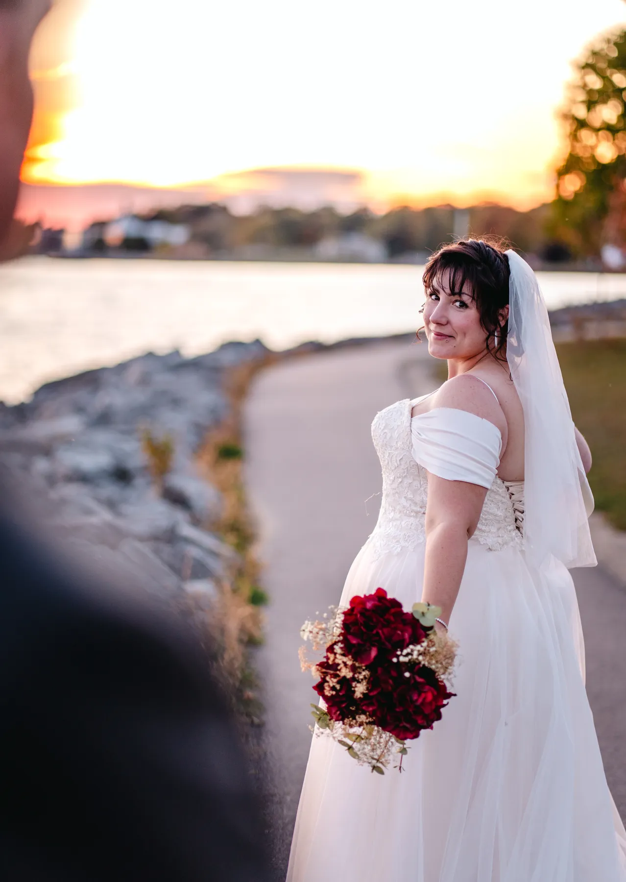 The bride posing by the water at sunset at Kody and Jaz’s wedding.