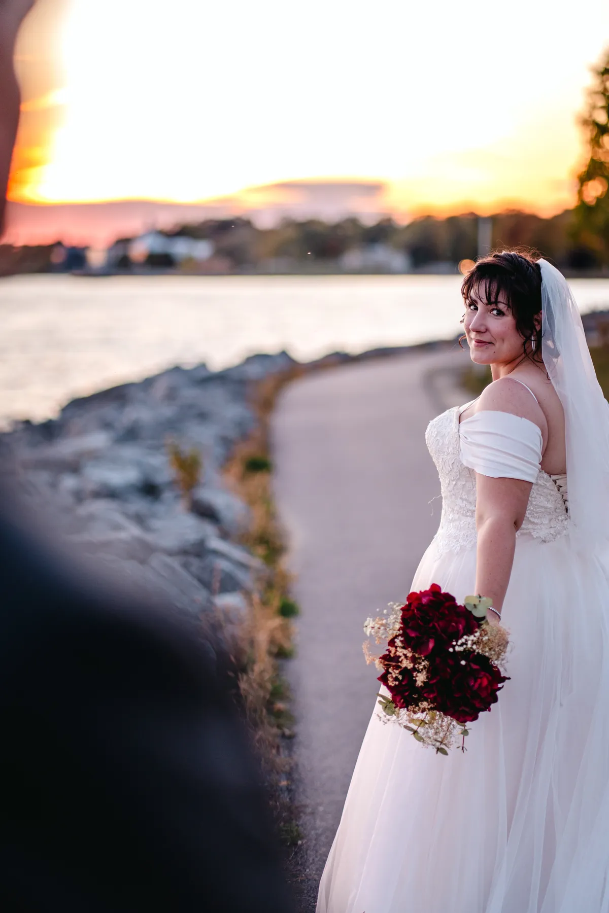 The bride posing by the water at sunset at Kody and Jaz’s wedding.