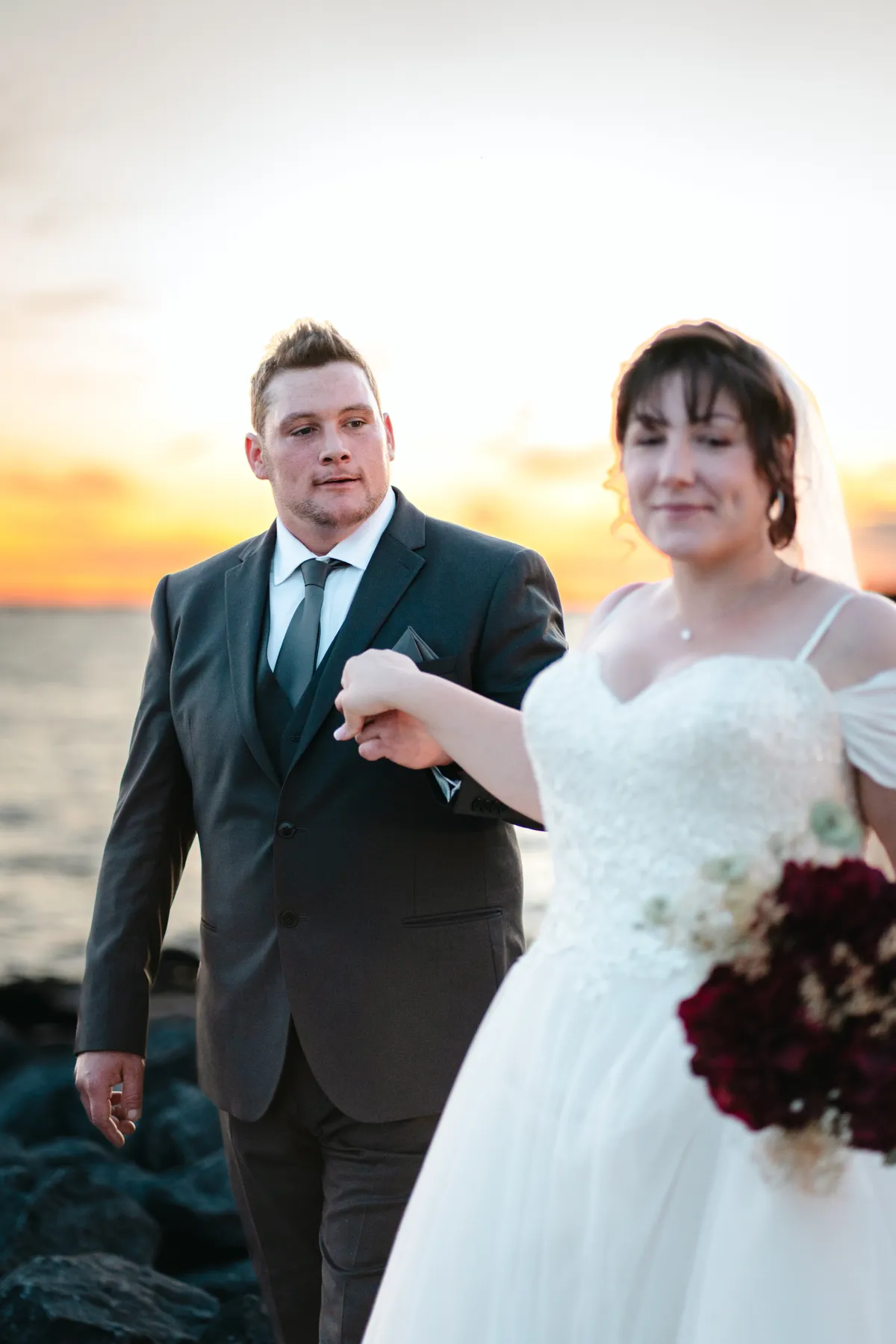 The couple posing by the water at sunset at Kody and Jaz’s wedding.